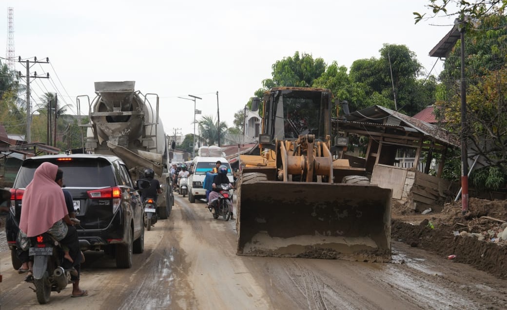 Alat berat Kementerian PU sedang membersihkan lumpur akibat bencana. (SinPo.id/dok. PU)