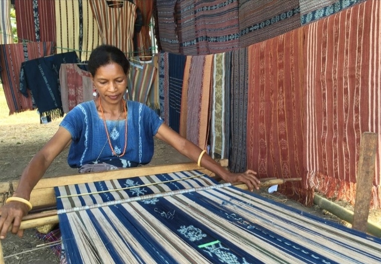 Ilustrasi seorang perempuan sedang menenun pakai alat tradisional. (SinPo.id/dok. Lakumas)