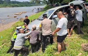 Anggota polisi membantu evakuasi mobil di Sungai Ogan (SinPo.id/ Humas Polri)