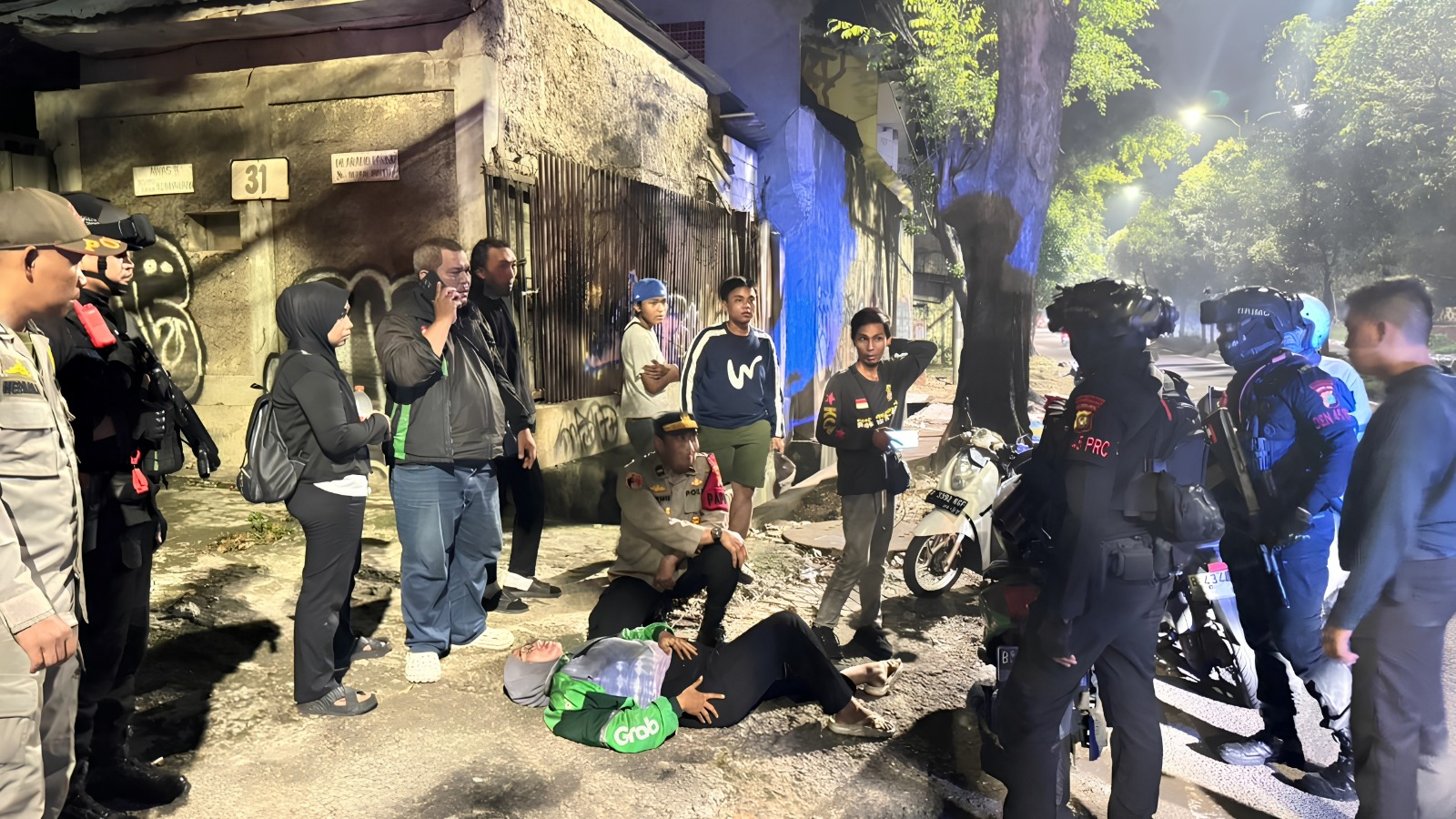 Satbrimob Polda Metro Jaya mengevakuasi pengemudi ojol (SinPo/Dok.PMJ)