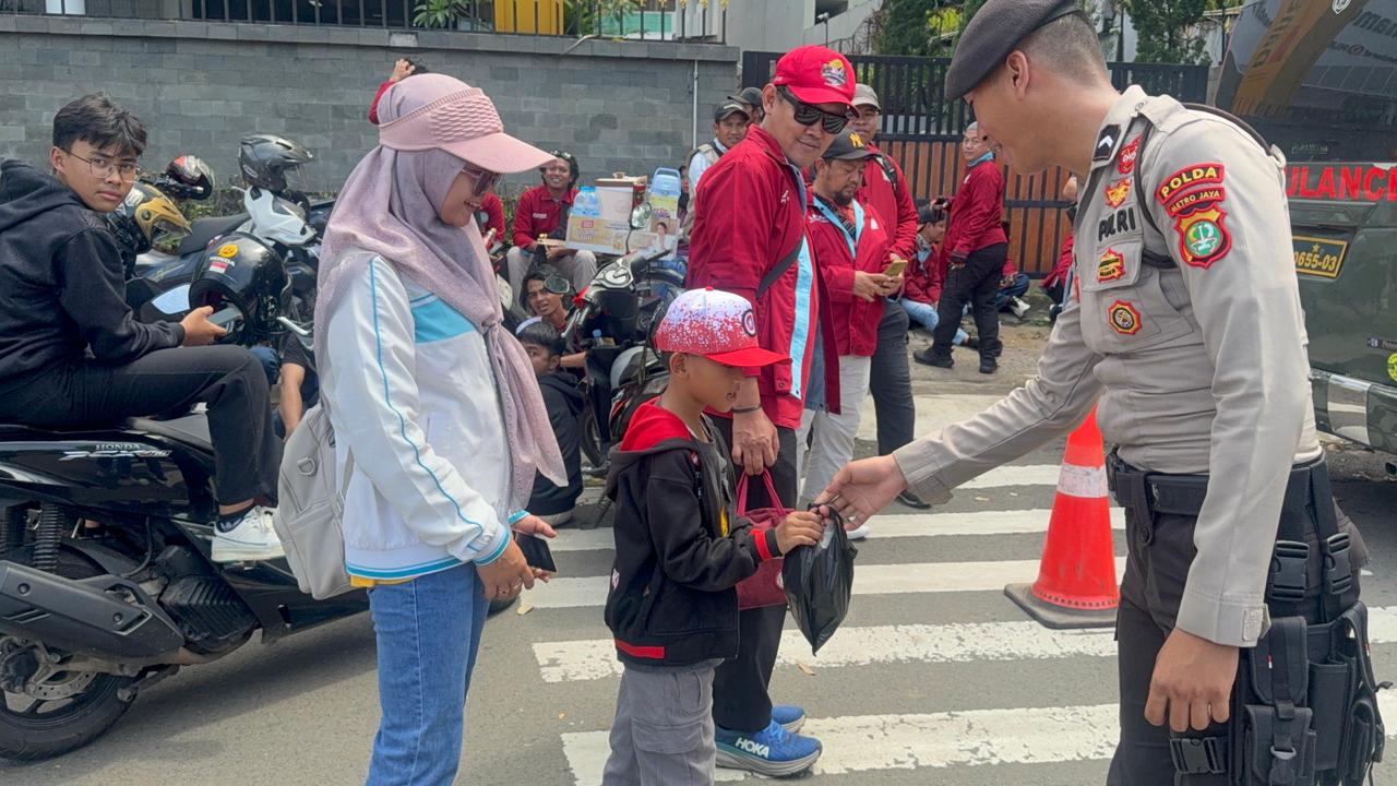 Anggota polisi membagikan makanan di May Day Jakpus (SinPo.id/Dok.PMJ)
