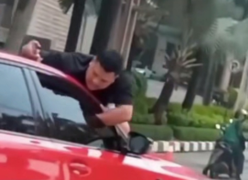 Seorang pria bergelantungan di kap mobil di kawasan Grogol (SinPo.id/Tangkapan layar)