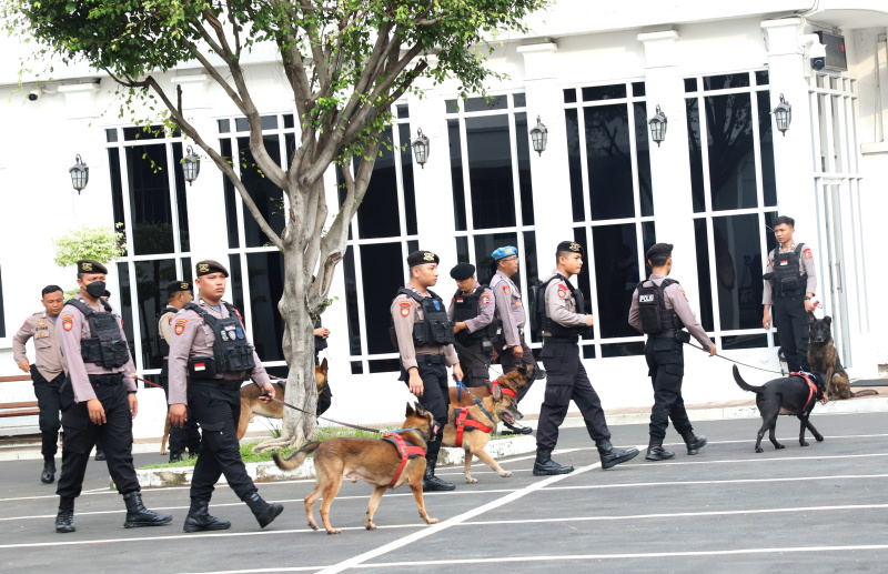Anggota polri melakukan pengamanan menyisir dengan anjing pelacak di Gedung KPU untuk memastikan keamanan menjelang penetapan Presiden dan Wakil Presiden (Ashar/SinPo.id)