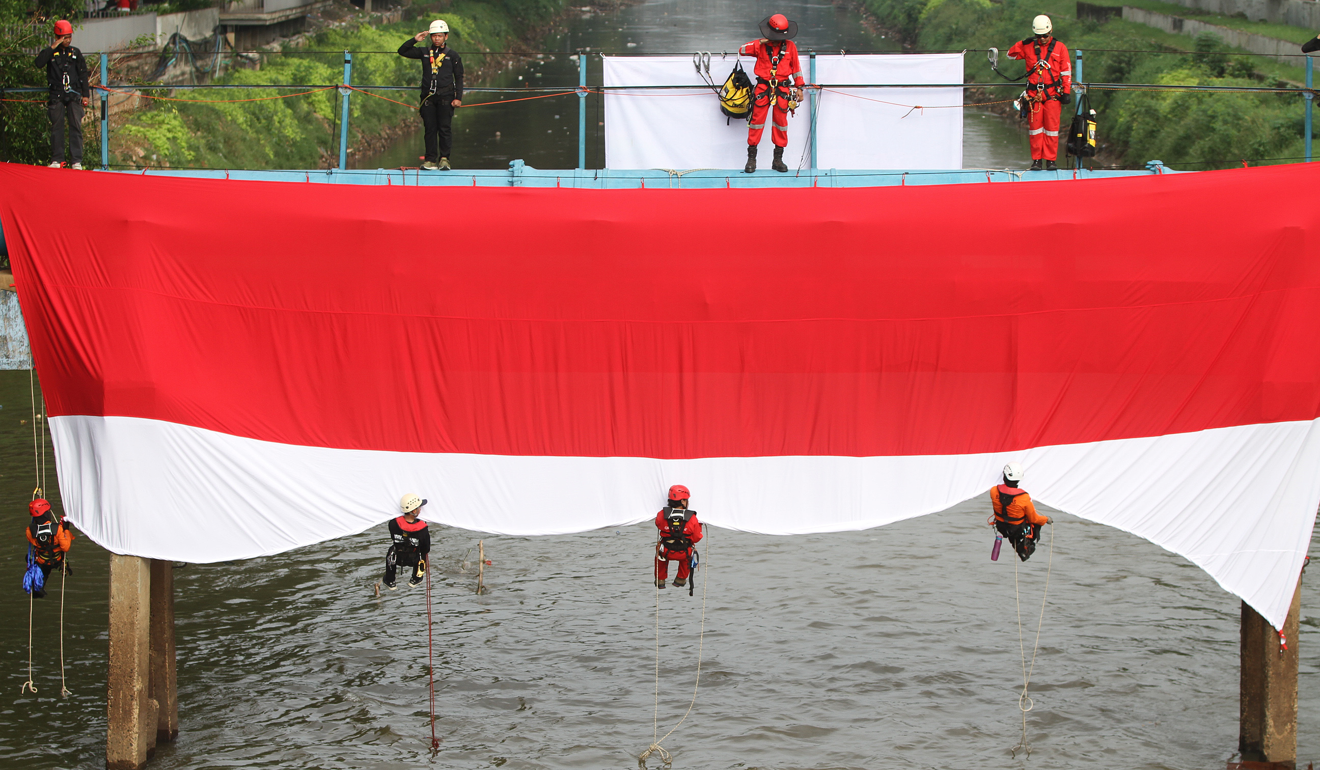 Bendera Merah Putih di Sungai Ciliwung. (Agus Priatna/SinPo.id)