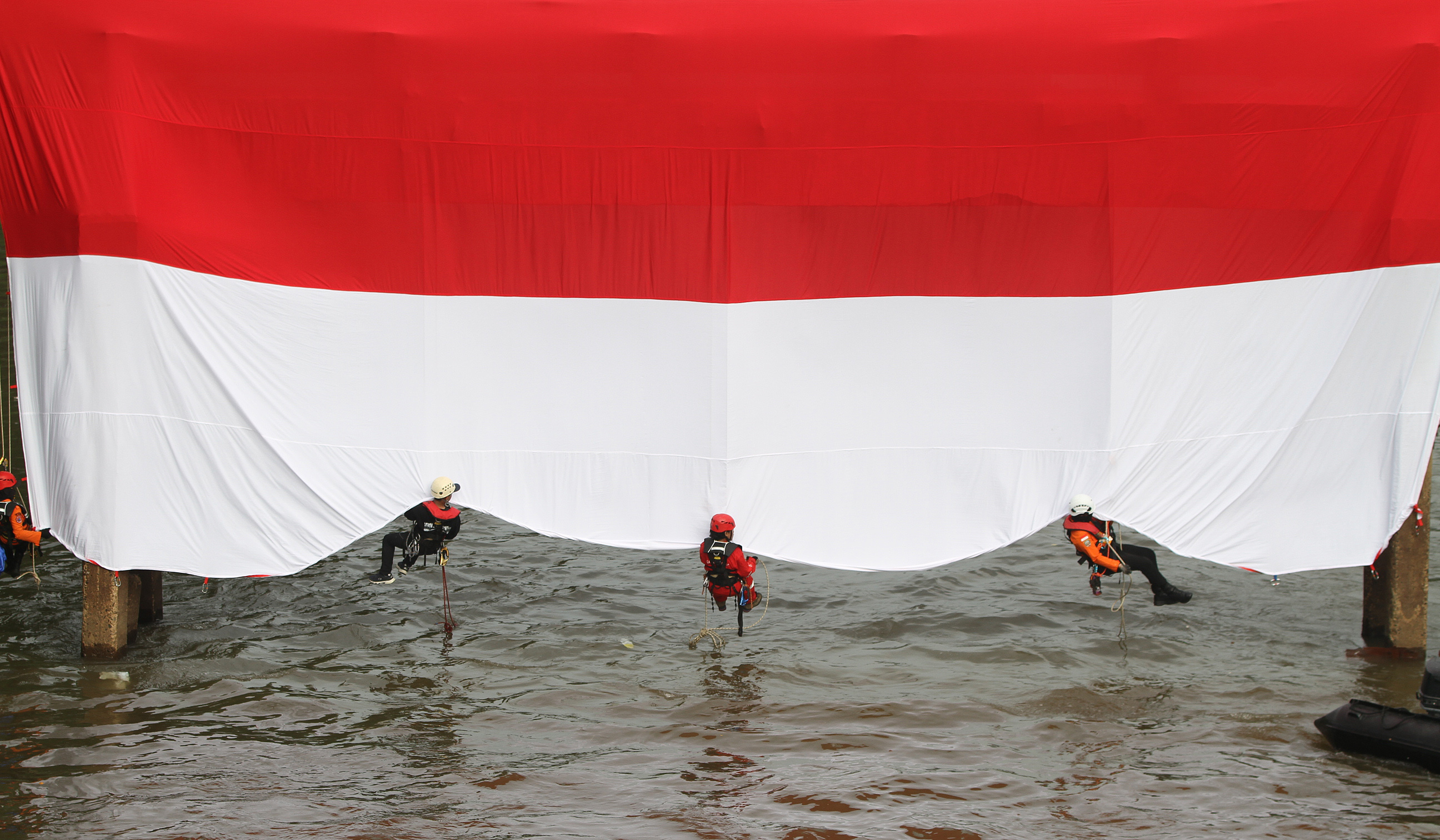 Bendera Merah Putih di Sungai Ciliwung. (Agus Priatna/SinPo.id)