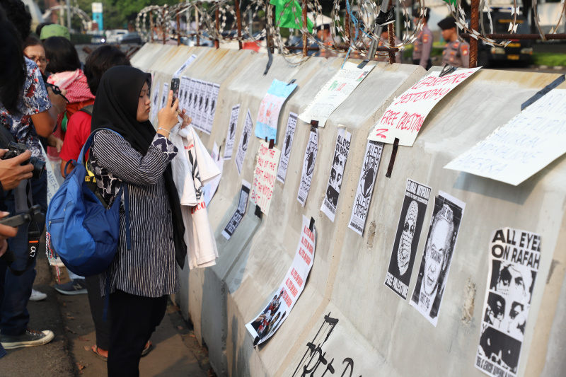 Aktivis gelar aksi solidaritas bela Palestina di depan Kedubes AS dengan membawa poster