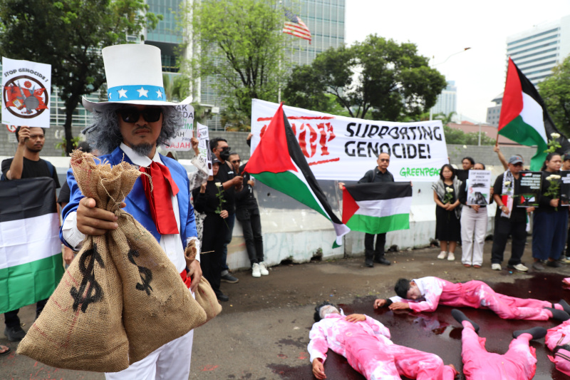 Aktivis Greenpeace menggelar aksi damai teaterikal dengan tajuk