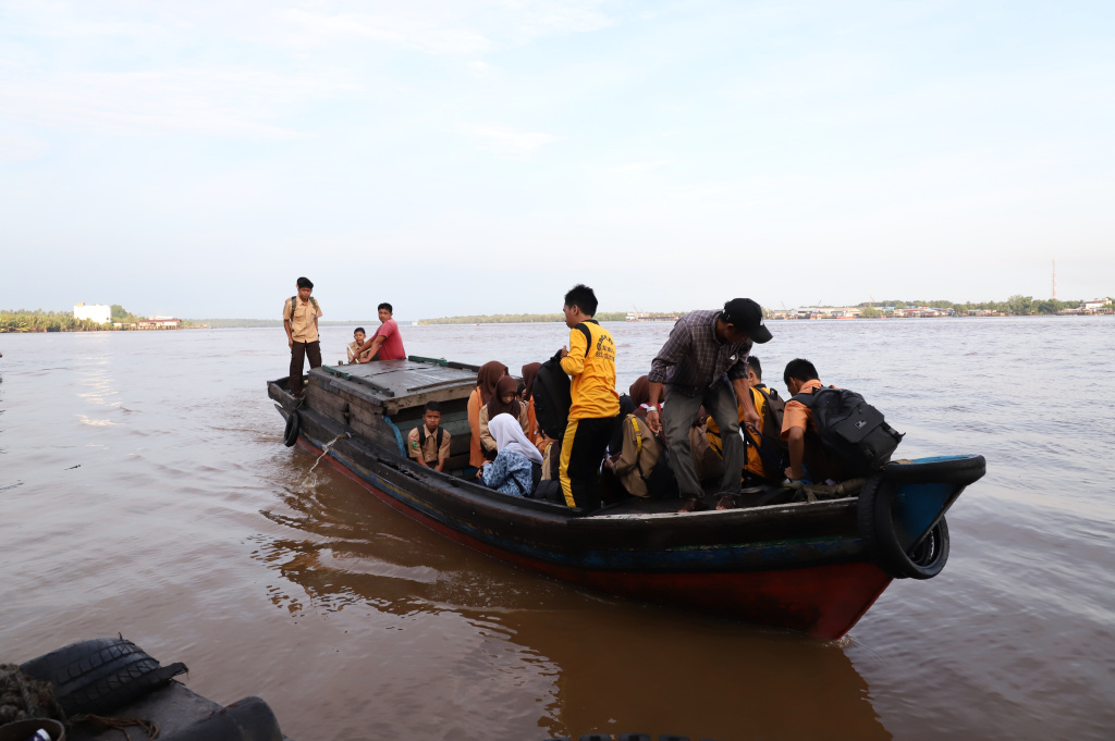 Aktivitas Anak Pulau Pucung Sebrangi Sungai Guntung Indragiri hilir Riau untuk berangkat ke Sekolah (Ashar/SinPo.id)