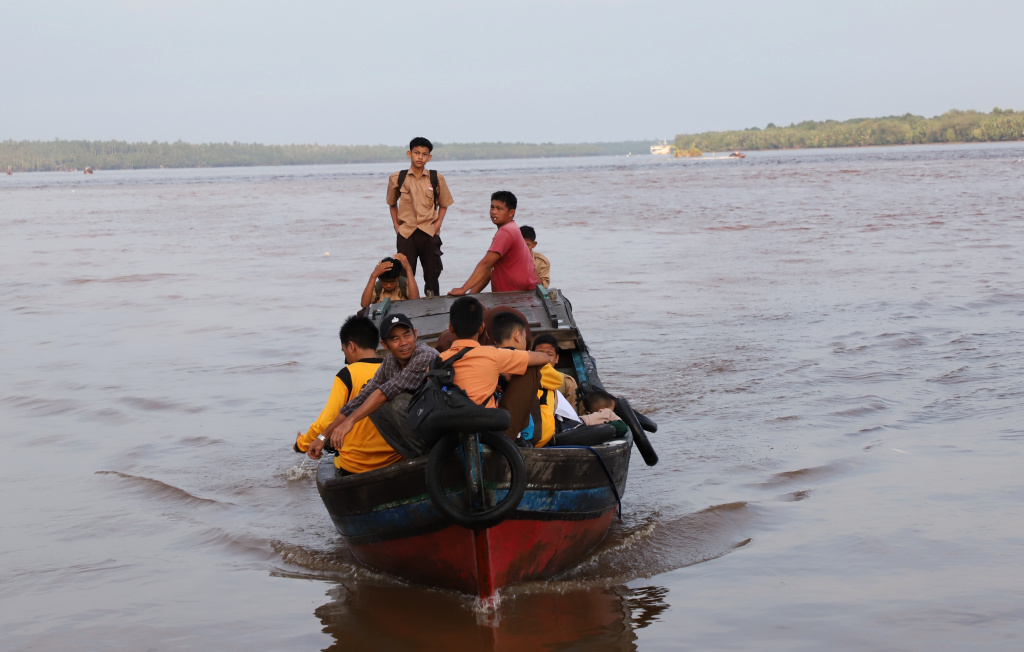 Aktivitas Anak Pulau Pucung Sebrangi Sungai Guntung Indragiri hilir Riau untuk berangkat ke Sekolah (Ashar/SinPo.id)