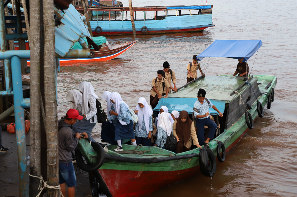 Aktivitas Anak Pulau Pucung Sebrangi Sungai Guntung Indragiri hilir Riau untuk berangkat ke Sekolah (Ashar/SinPo.id)