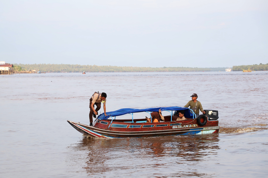 Aktivitas Anak Pulau Pucung Sebrangi Sungai Guntung Indragiri hilir Riau untuk berangkat ke Sekolah (Ashar/SinPo.id)