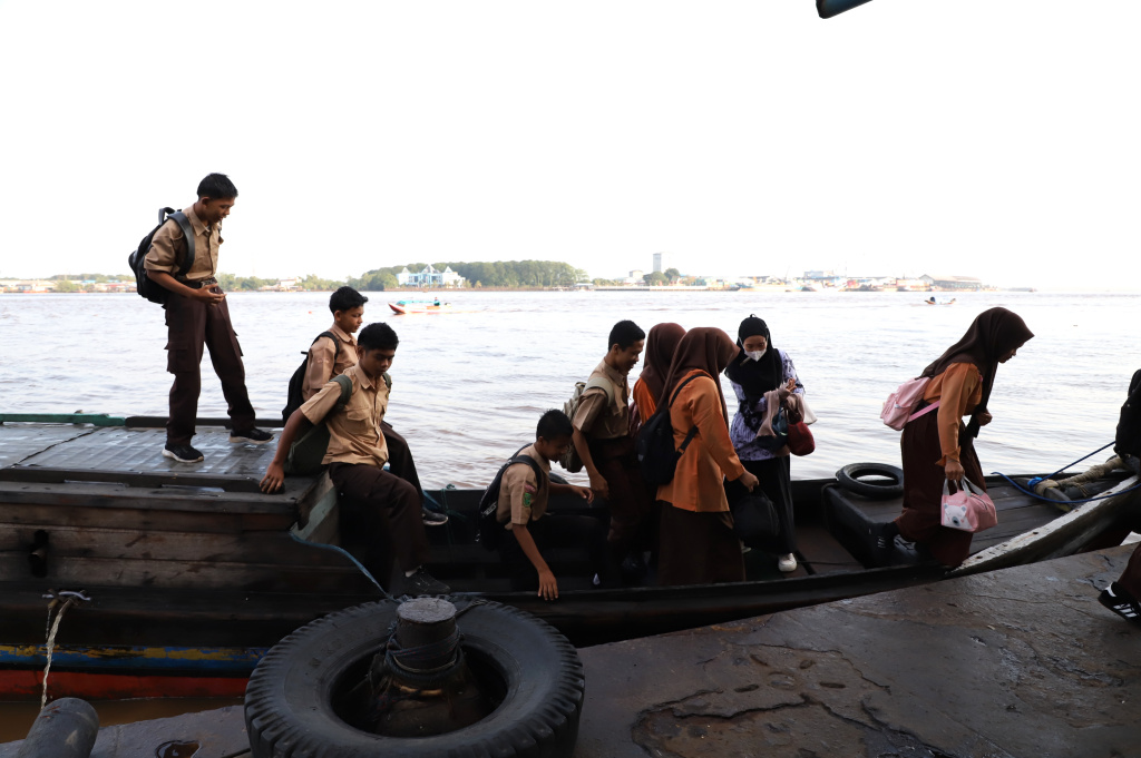 Aktivitas Anak Pulau Pucung Sebrangi Sungai Guntung Indragiri hilir Riau untuk berangkat ke Sekolah (Ashar/SinPo.id)