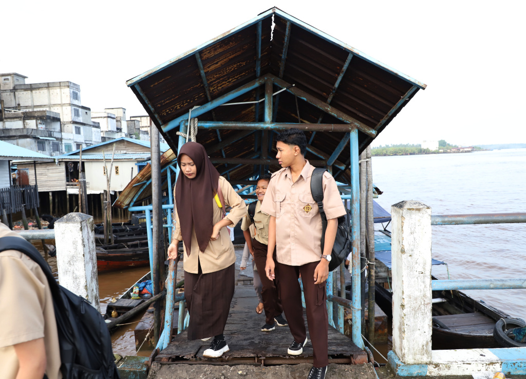Aktivitas Anak Pulau Pucung Sebrangi Sungai Guntung Indragiri hilir Riau untuk berangkat ke Sekolah (Ashar/SinPo.id)