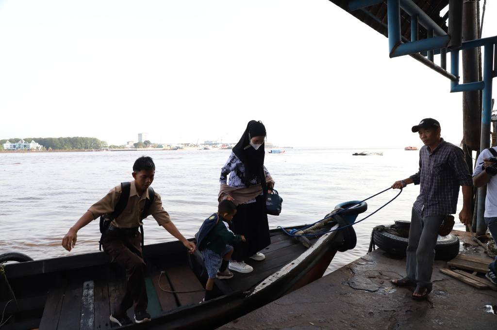 Aktivitas Anak Pulau Pucung Sebrangi Sungai Guntung Indragiri hilir Riau untuk berangkat ke Sekolah (Ashar/SinPo.id)