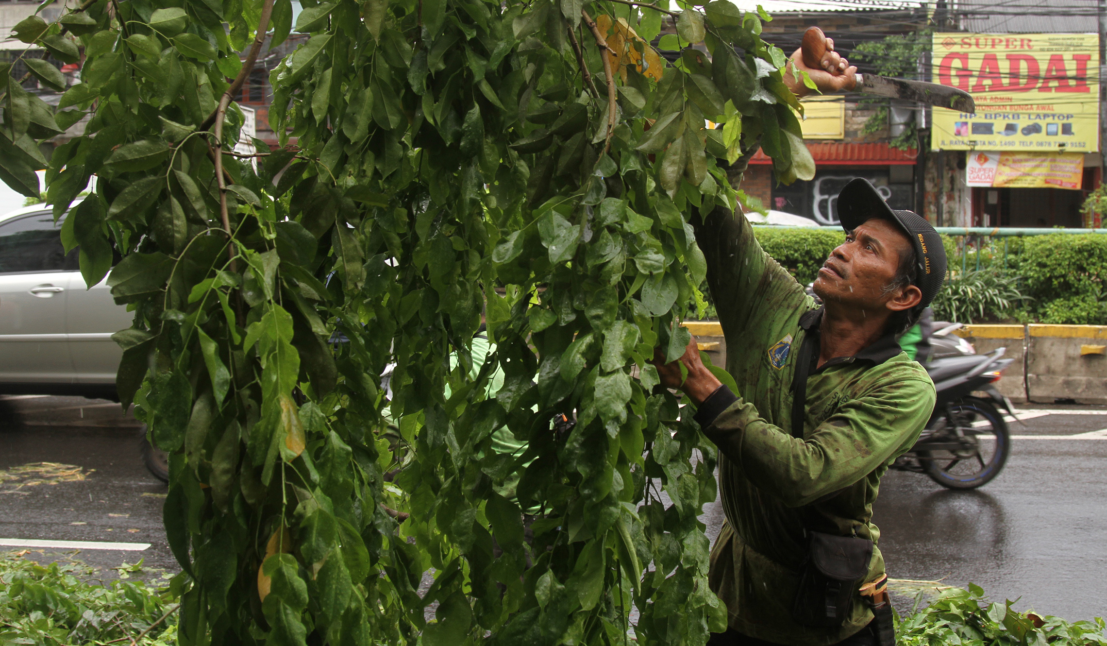Pemangkasan pohon di jalan Otista Raya. (Agus Priatna/SinPo.id)