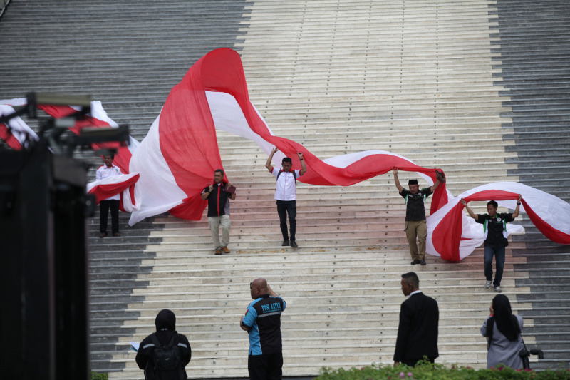Asosiasi Pengemudi kibarkan bendera merah-putih sepanjang 200 meter di Gedung Nusantara DPR untuk menyambut hari kemerdekaan 17 Agustus (Ashar/SinPo.id)