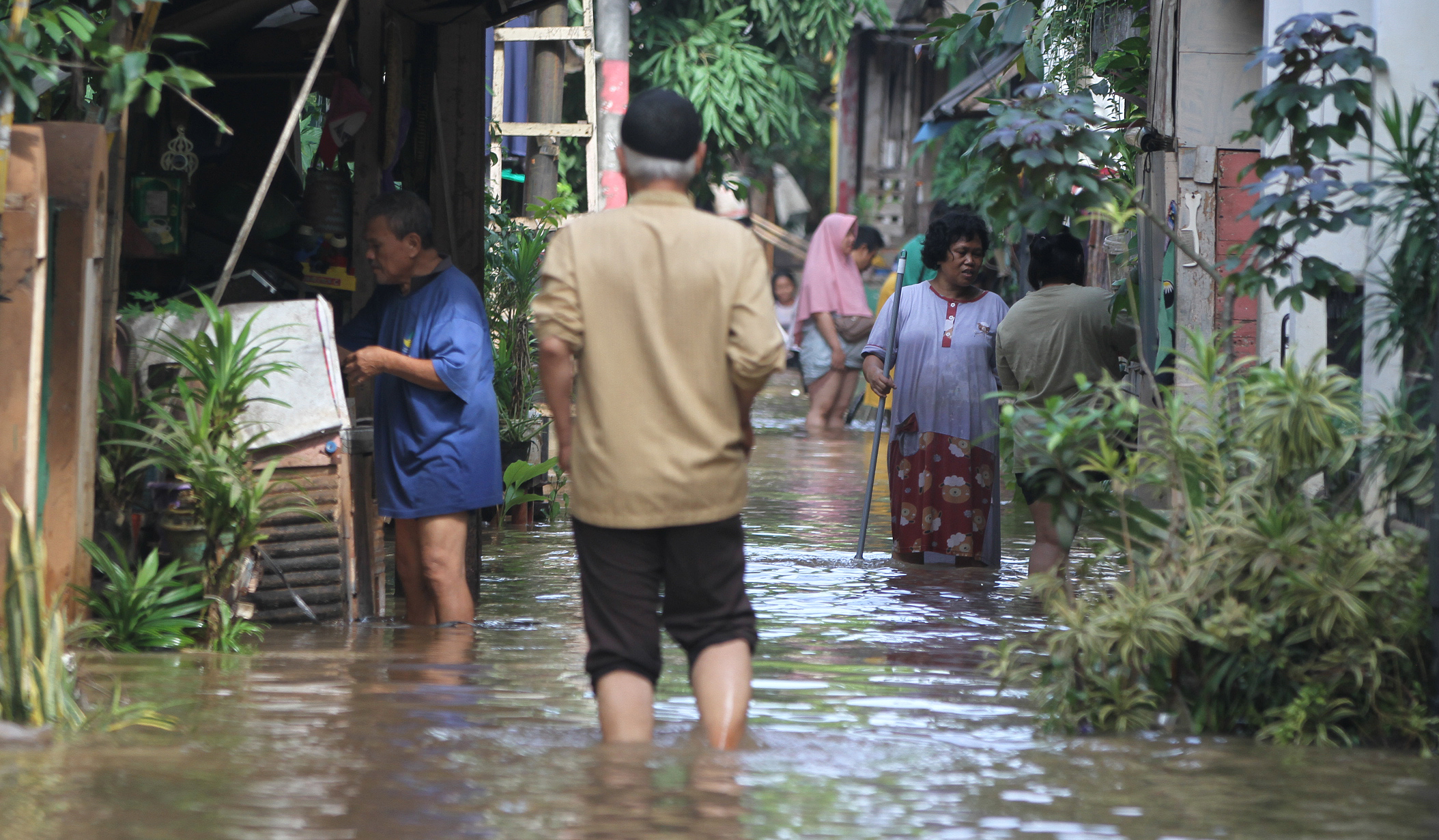 Warga melakukan aktivitas saat banjir merendam pemukiman warga di Kawasan Cipinang Melayu, Jakarta, Senin (7 Juli 2025).