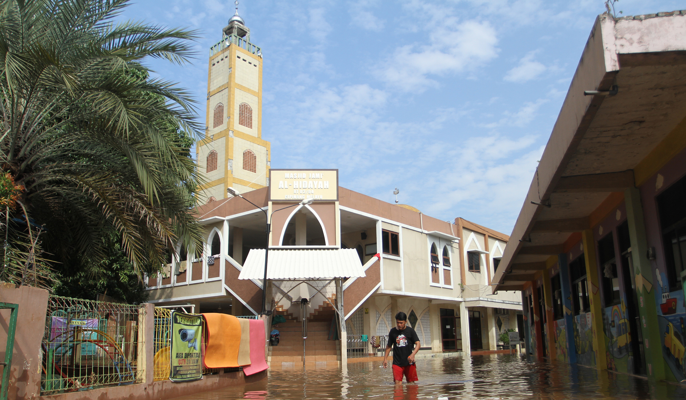 Warga melakukan aktivitas saat banjir merendam pemukiman warga di Kawasan Cipinang Melayu, Jakarta, Senin (7 Juli 2025).