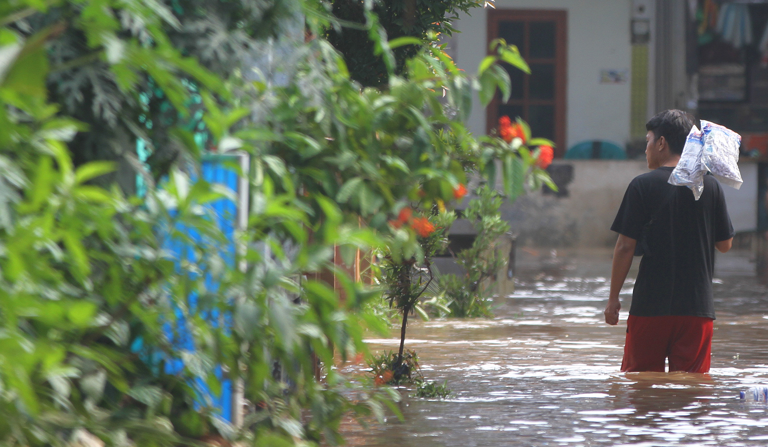 Warga melakukan aktivitas saat banjir merendam pemukiman warga di Kawasan Cipinang Melayu, Jakarta, Senin (7 Juli 2025).