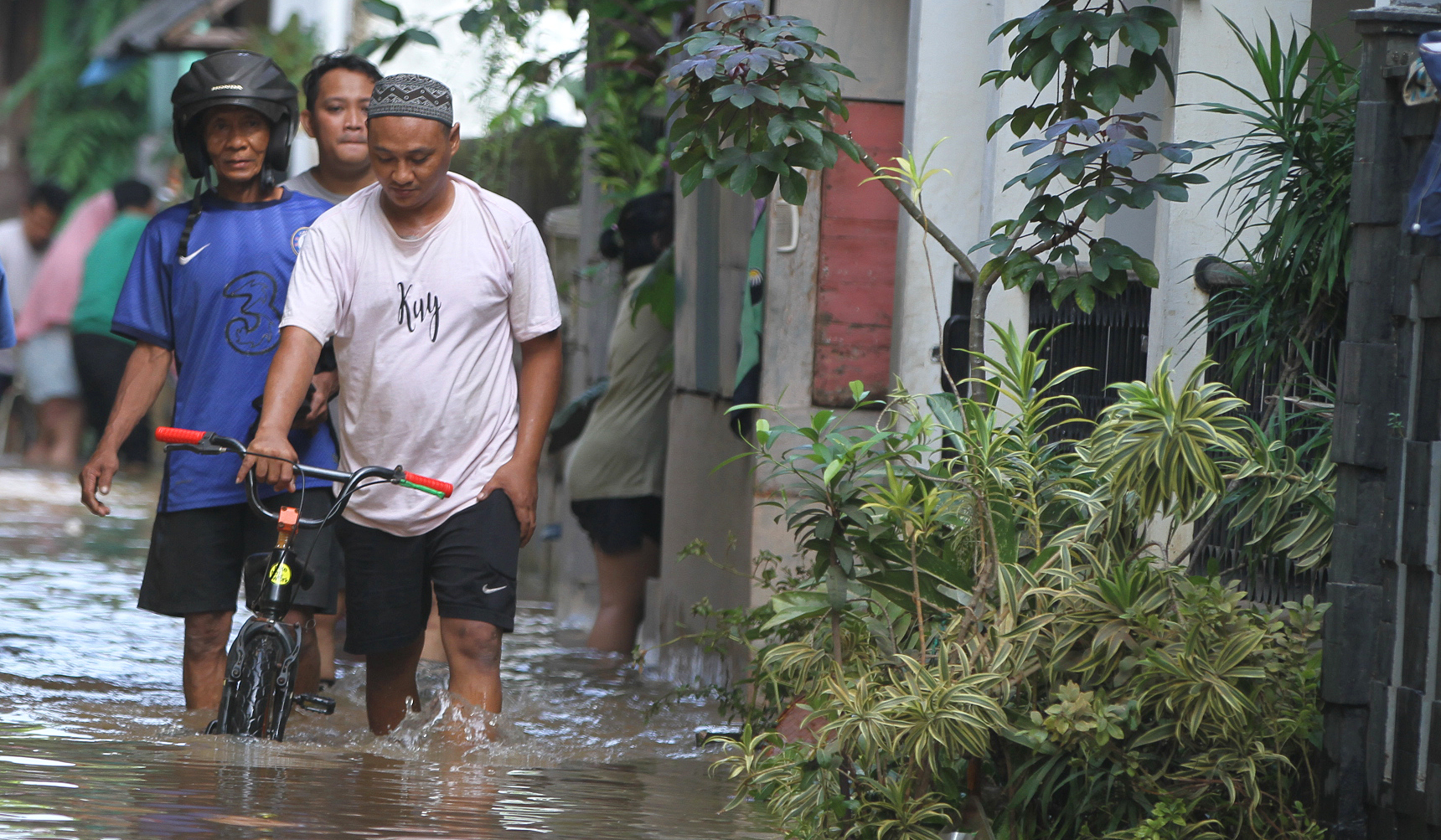 Warga melakukan aktivitas saat banjir merendam pemukiman warga di Kawasan Cipinang Melayu, Jakarta, Senin (7 Juli 2025).