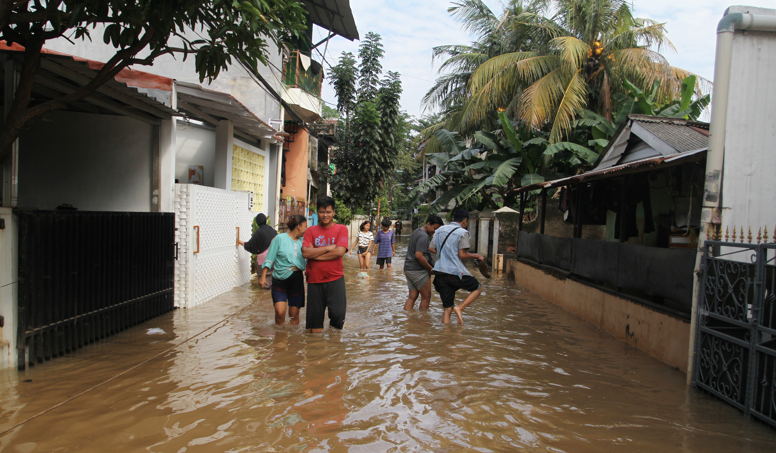 Warga melakukan aktivitas saat banjir merendam pemukiman warga di Kawasan Cipinang Melayu, Jakarta, Senin (7 Juli 2025).
