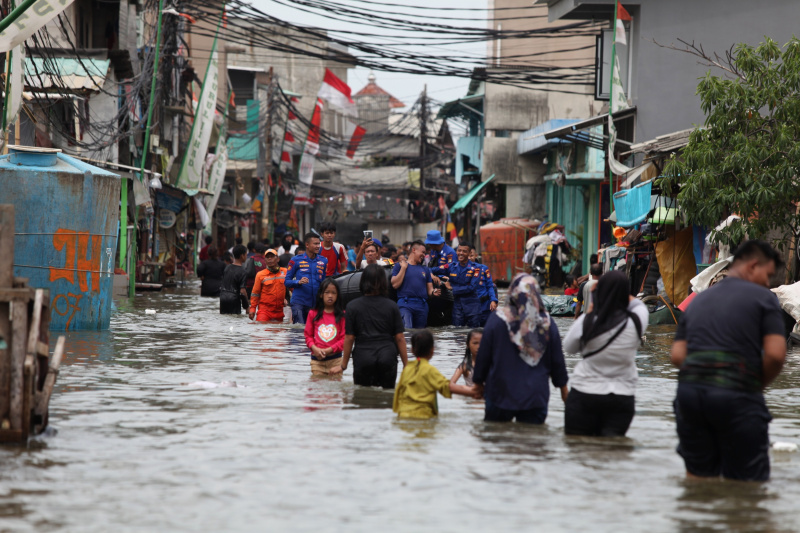 Sejumlah anak-anak sedang bermain banjir rob setinggi 30 Cm di Muara Angke (Ashar/SinPo.id)