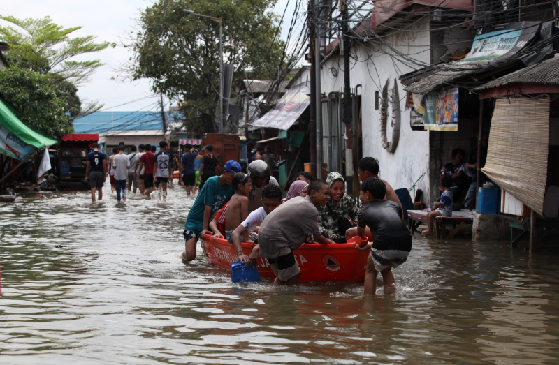 Sejumlah anak-anak sedang bermain banjir rob setinggi 30 Cm di Muara Angke (Ashar/SinPo.id)