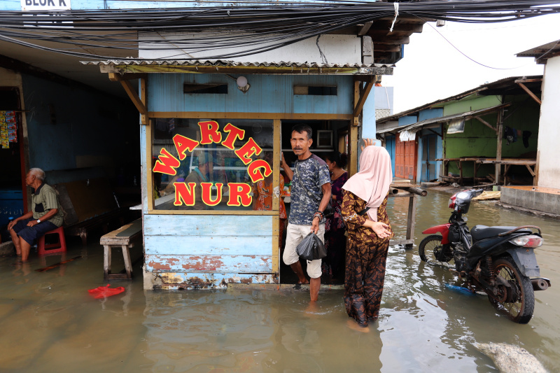 Sejumlah anak-anak sedang bermain banjir rob setinggi 30 Cm di Muara Angke (Ashar/SinPo.id)