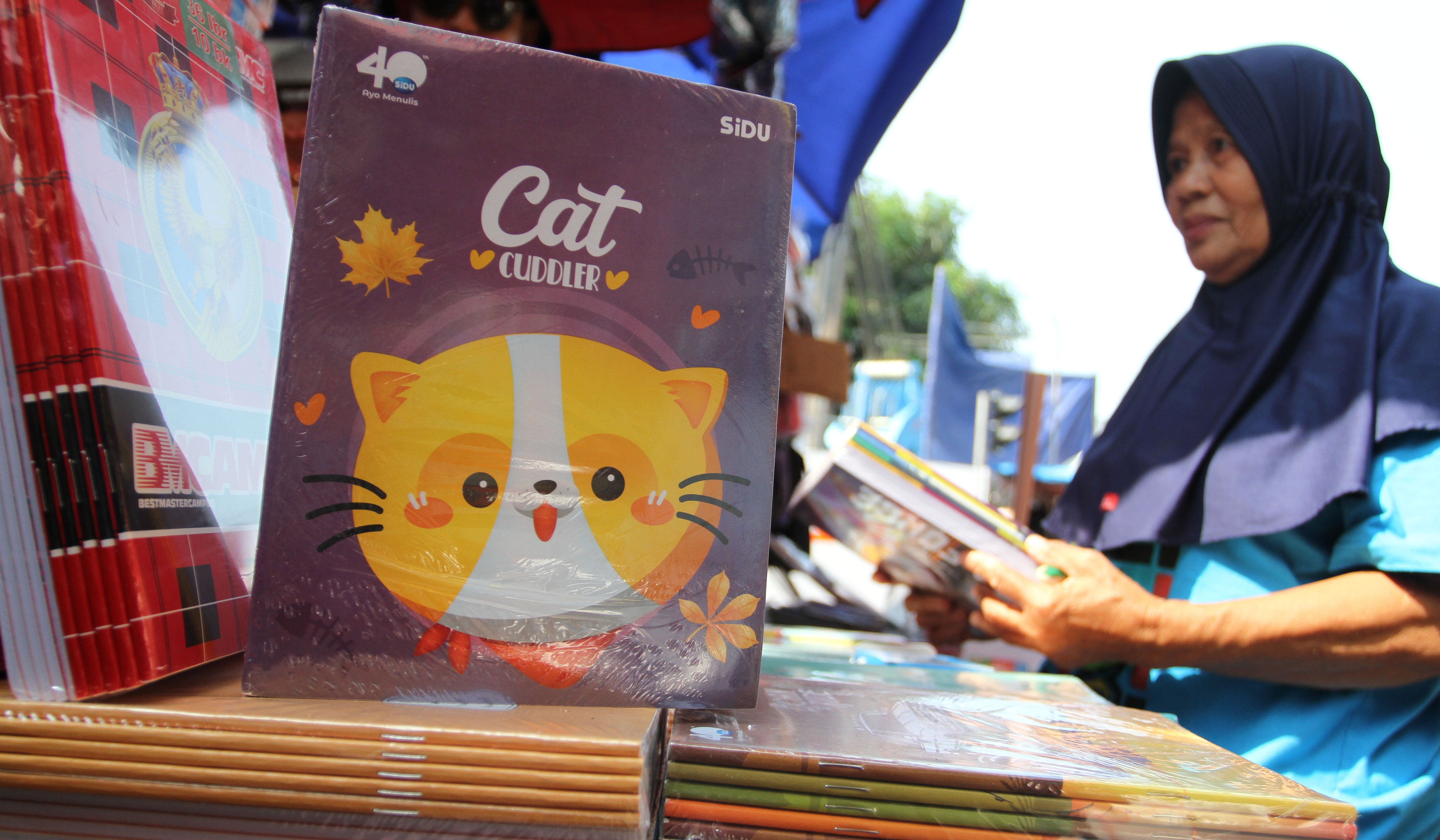 Pengunjung melihat buku tulis yang dijual di pasar pagi Asemka, Jakarta. (Agus Priatna/SinPo.id)