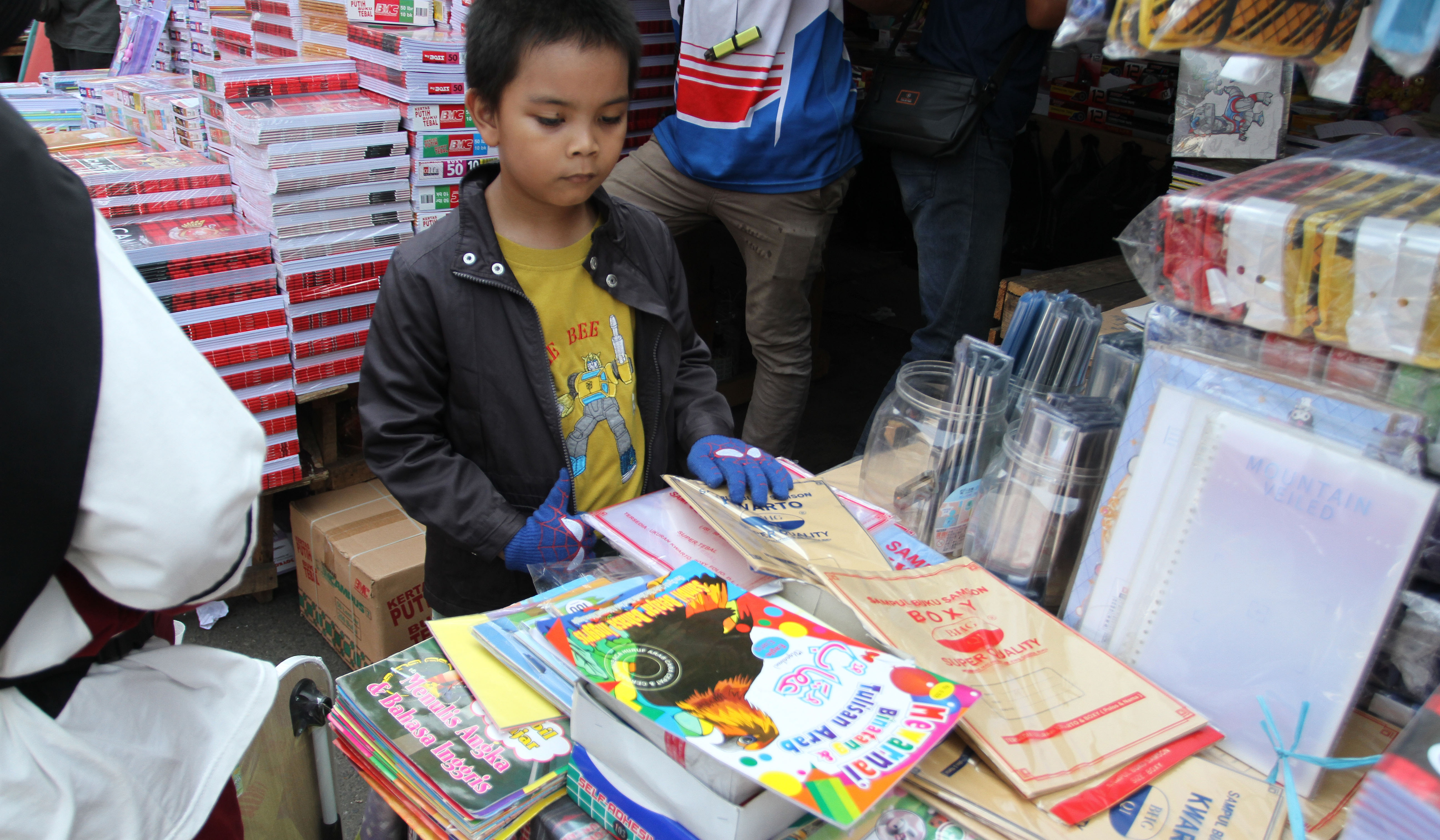 Pengunjung melihat buku tulis yang dijual di pasar pagi Asemka, Jakarta. (Agus Priatna/SinPo.id)