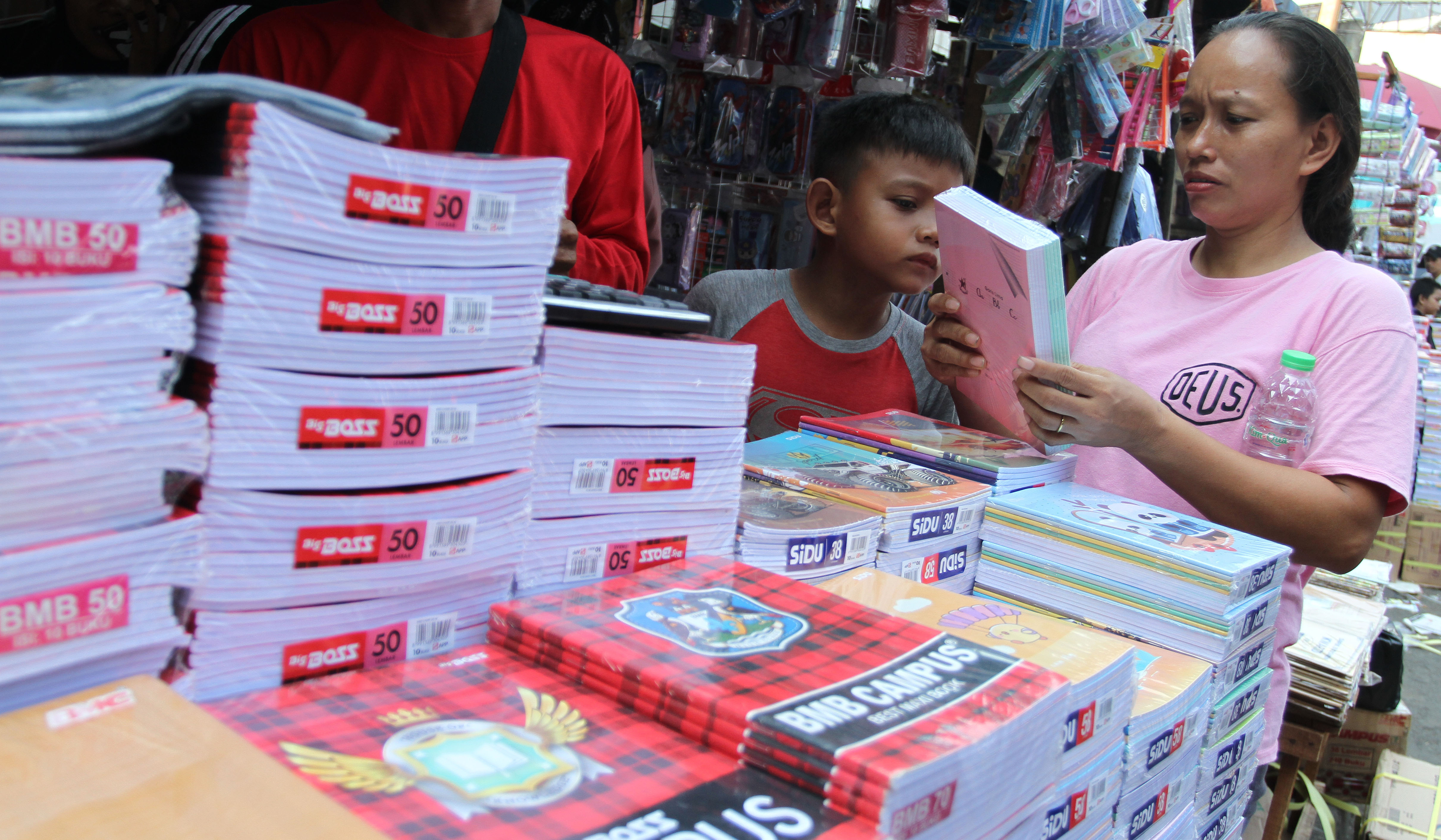Pengunjung melihat buku tulis yang dijual di pasar pagi Asemka, Jakarta. (Agus Priatna/SinPo.id)