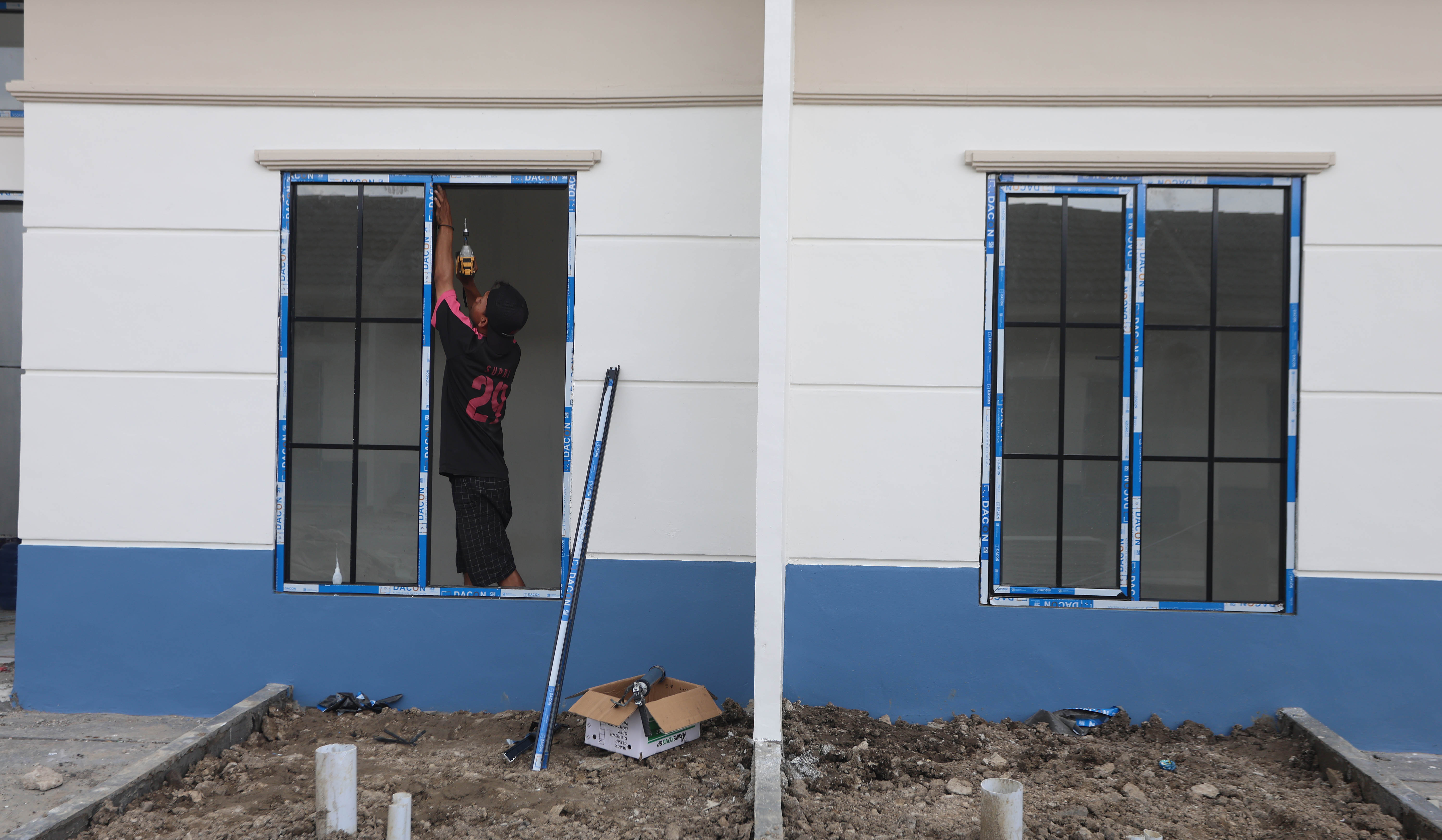 Pekerja menyelesaikan pembangunan rumah subsidi. (Agus Priatna/SinPo.id)