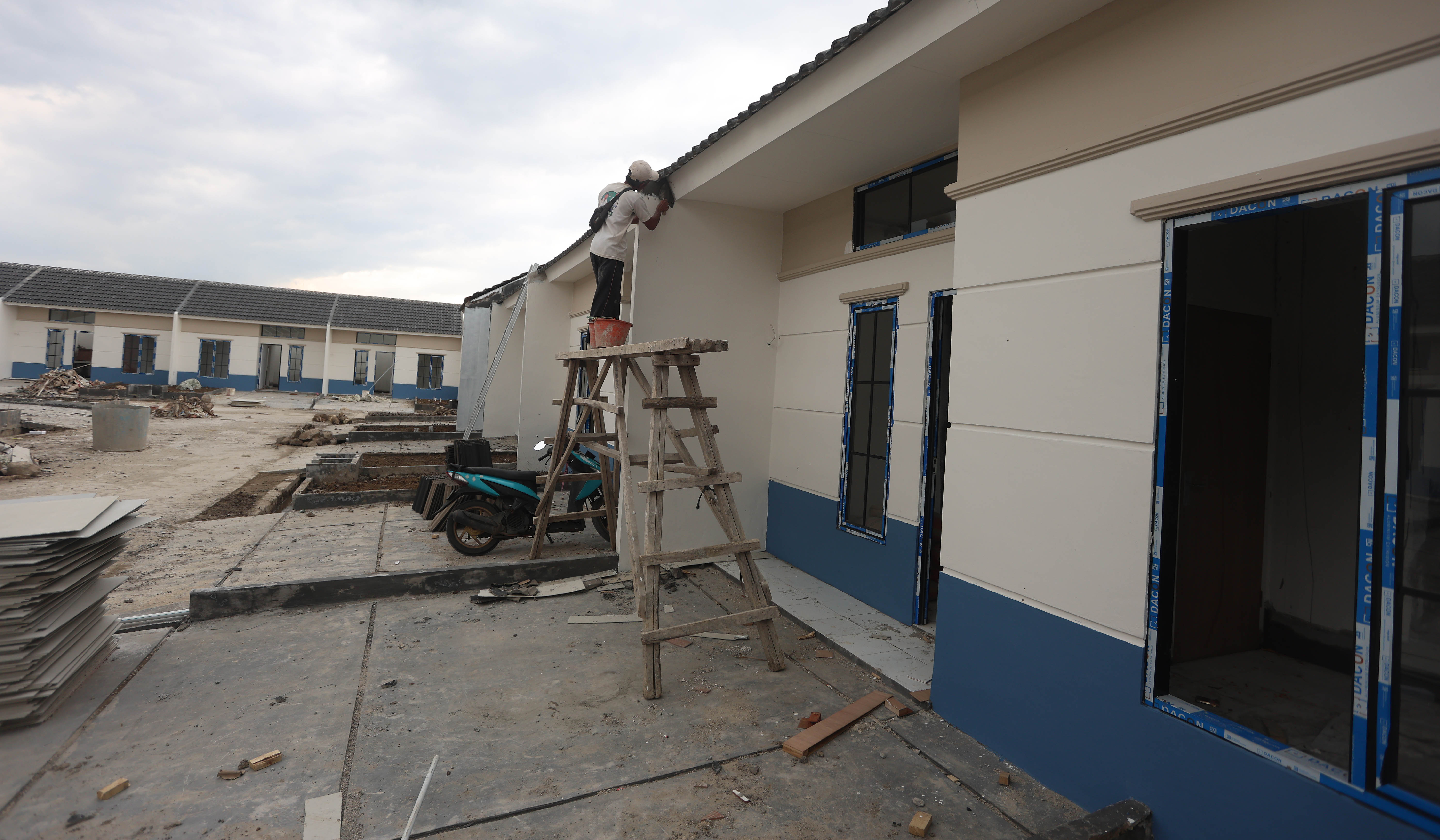 Pekerja menyelesaikan pembangunan rumah subsidi. (Agus Priatna/SinPo.id)