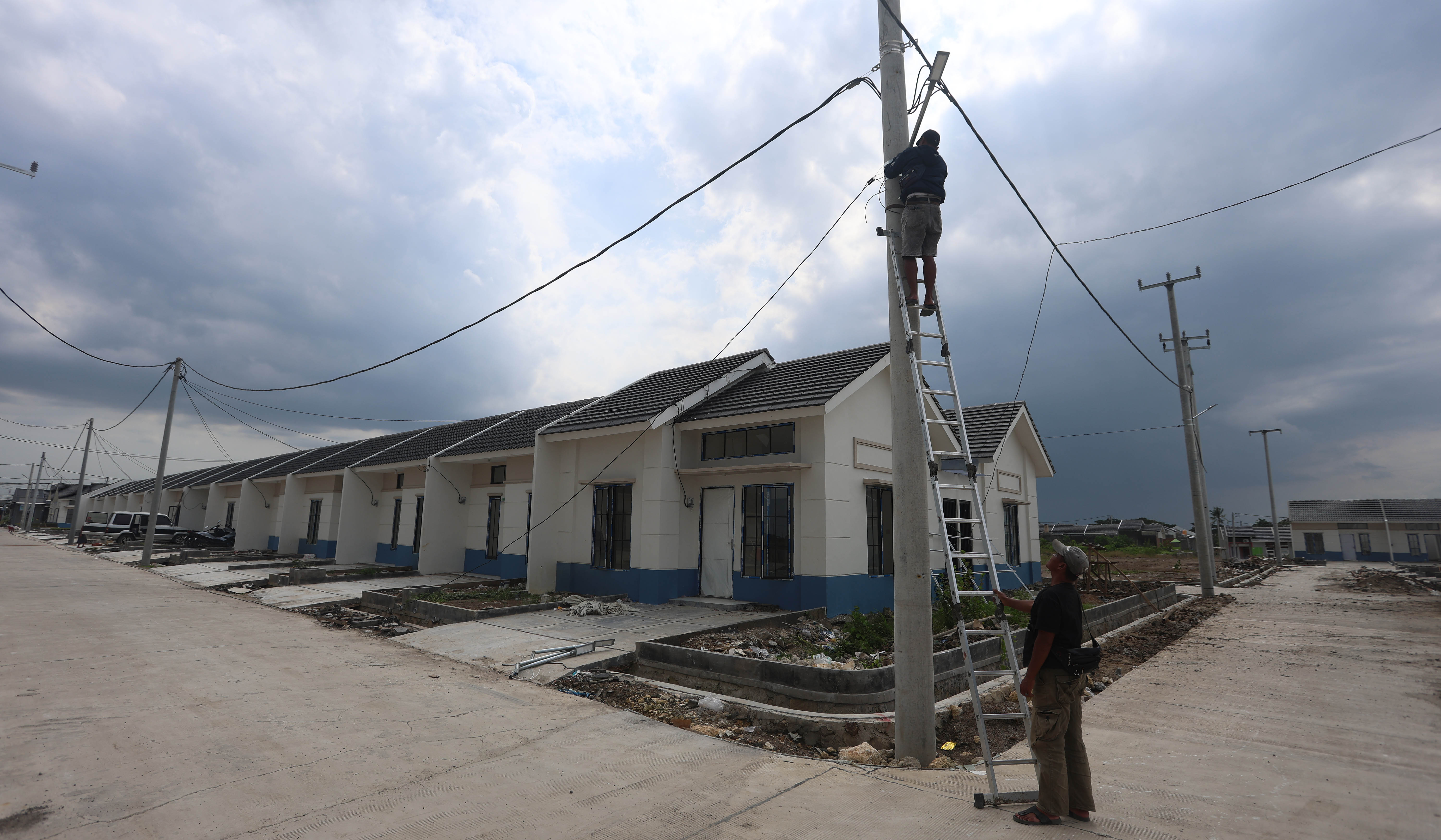 Pekerja menyelesaikan pembangunan rumah subsidi. (Agus Priatna/SinPo.id)