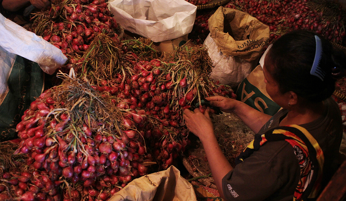 Pekerja mengupas bawang merah di Pasar Induk Kramat Jati. (Agus Priatna/SinPo.id)