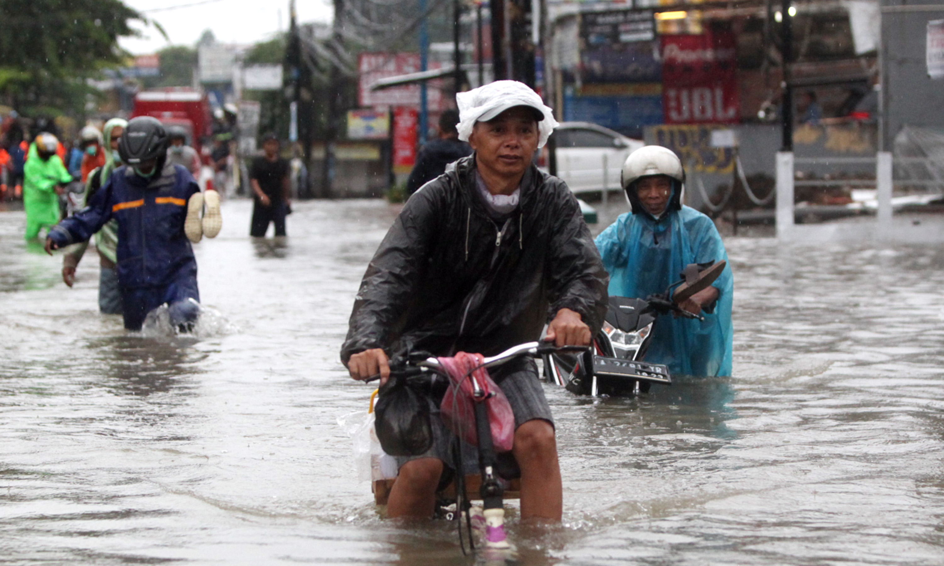 Sepanjang Jalan KH Hasyim Ashari digenangi air banjir sehingga terputus tidak bisa dilalui kendaraan bermotor (Ashar/SinPo.id)