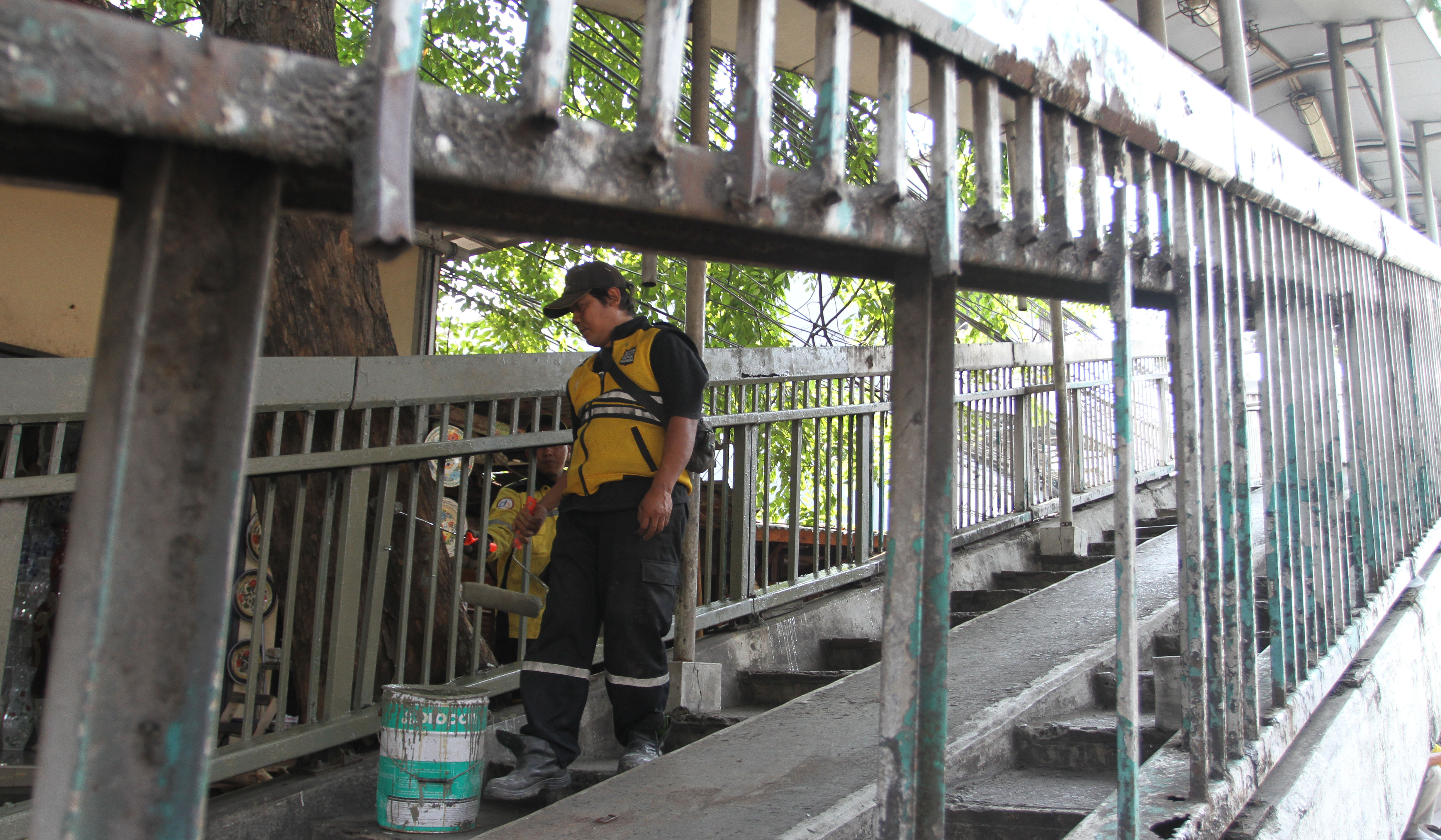 Petugas Dinas Bina Marga DKI Jakarta, memperbaiki Jembatan Penyeberangan Orang (JPO) di Jalan Yos Sudarso, Koja, Jakarta Utara. (Agus Priatna/SinPo.id)