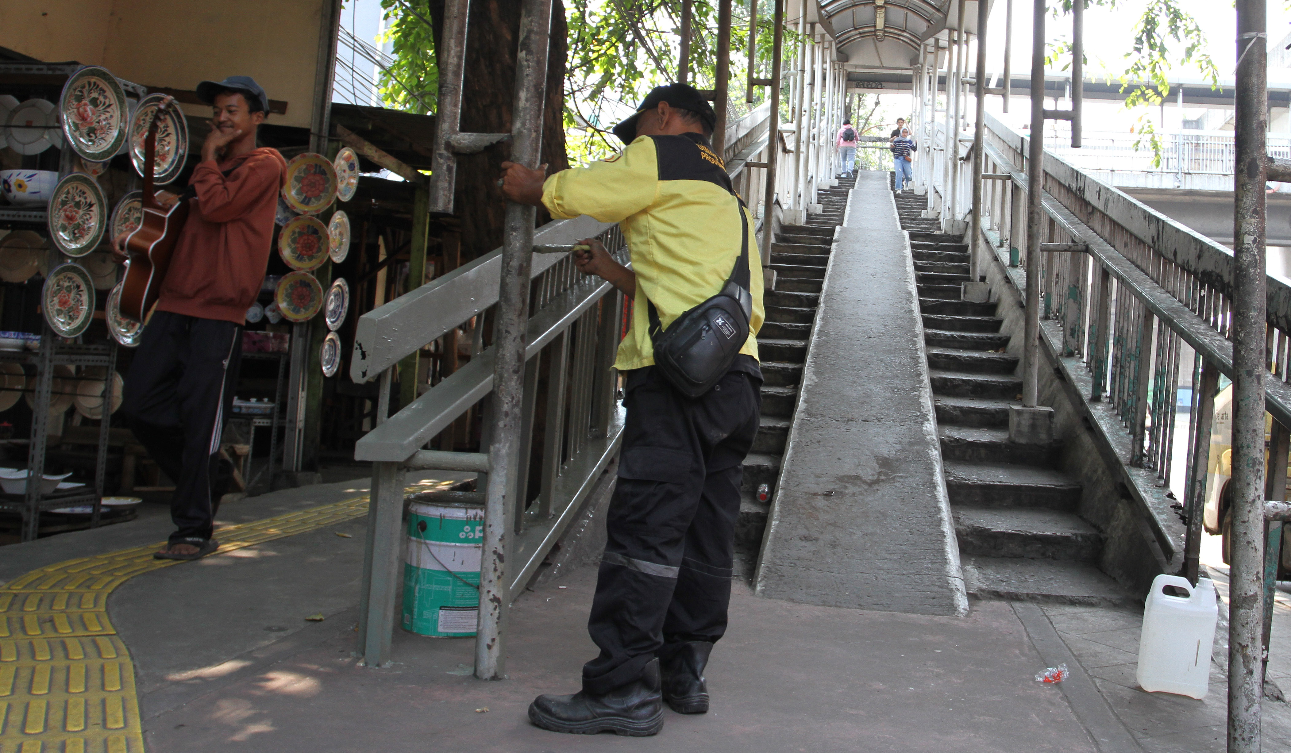 Petugas Dinas Bina Marga DKI Jakarta, memperbaiki Jembatan Penyeberangan Orang (JPO) di Jalan Yos Sudarso, Koja, Jakarta Utara. (Agus Priatna/SinPo.id)