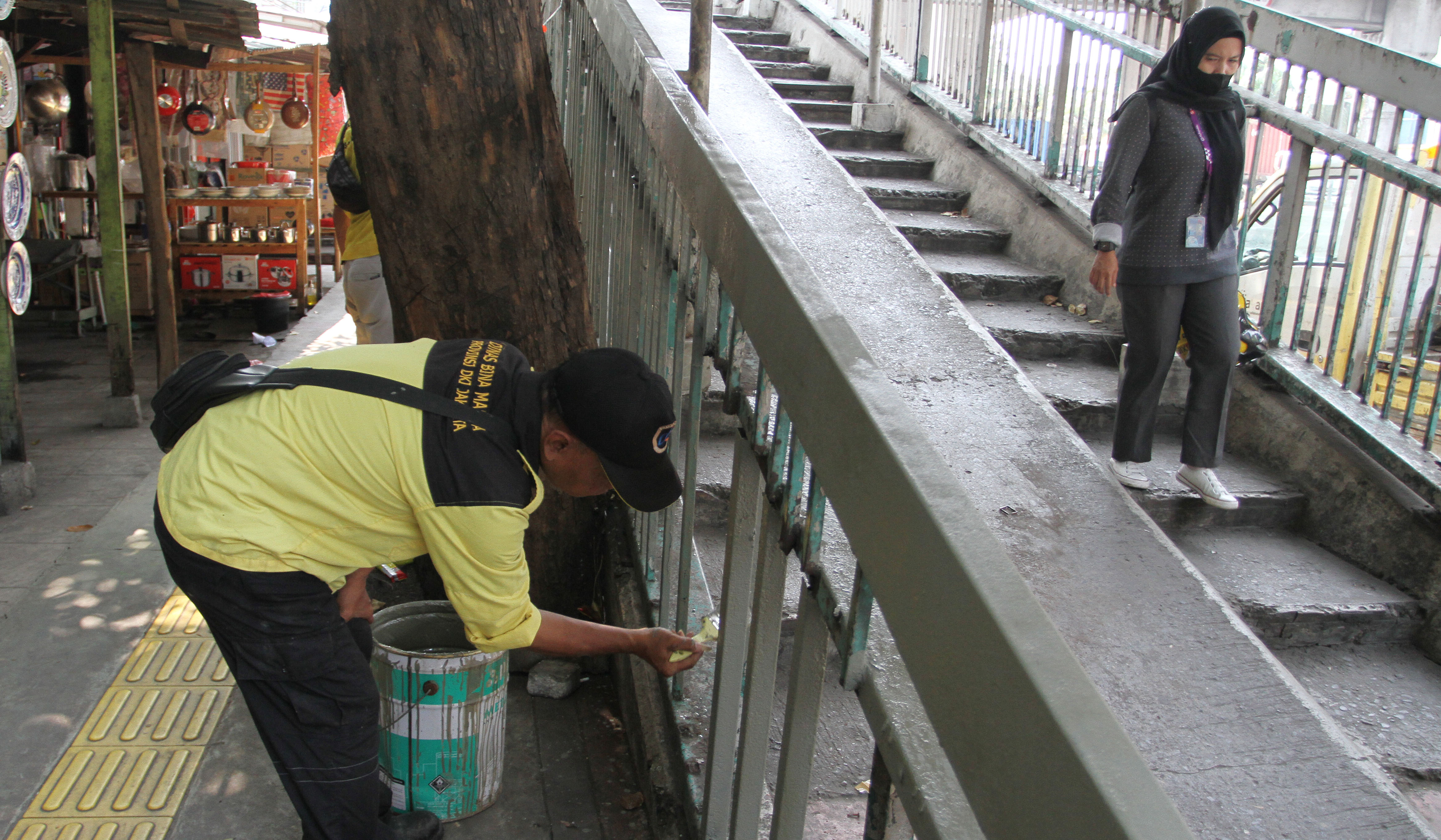 Petugas Dinas Bina Marga DKI Jakarta, memperbaiki Jembatan Penyeberangan Orang (JPO) di Jalan Yos Sudarso, Koja, Jakarta Utara. (Agus Priatna/SinPo.id)
