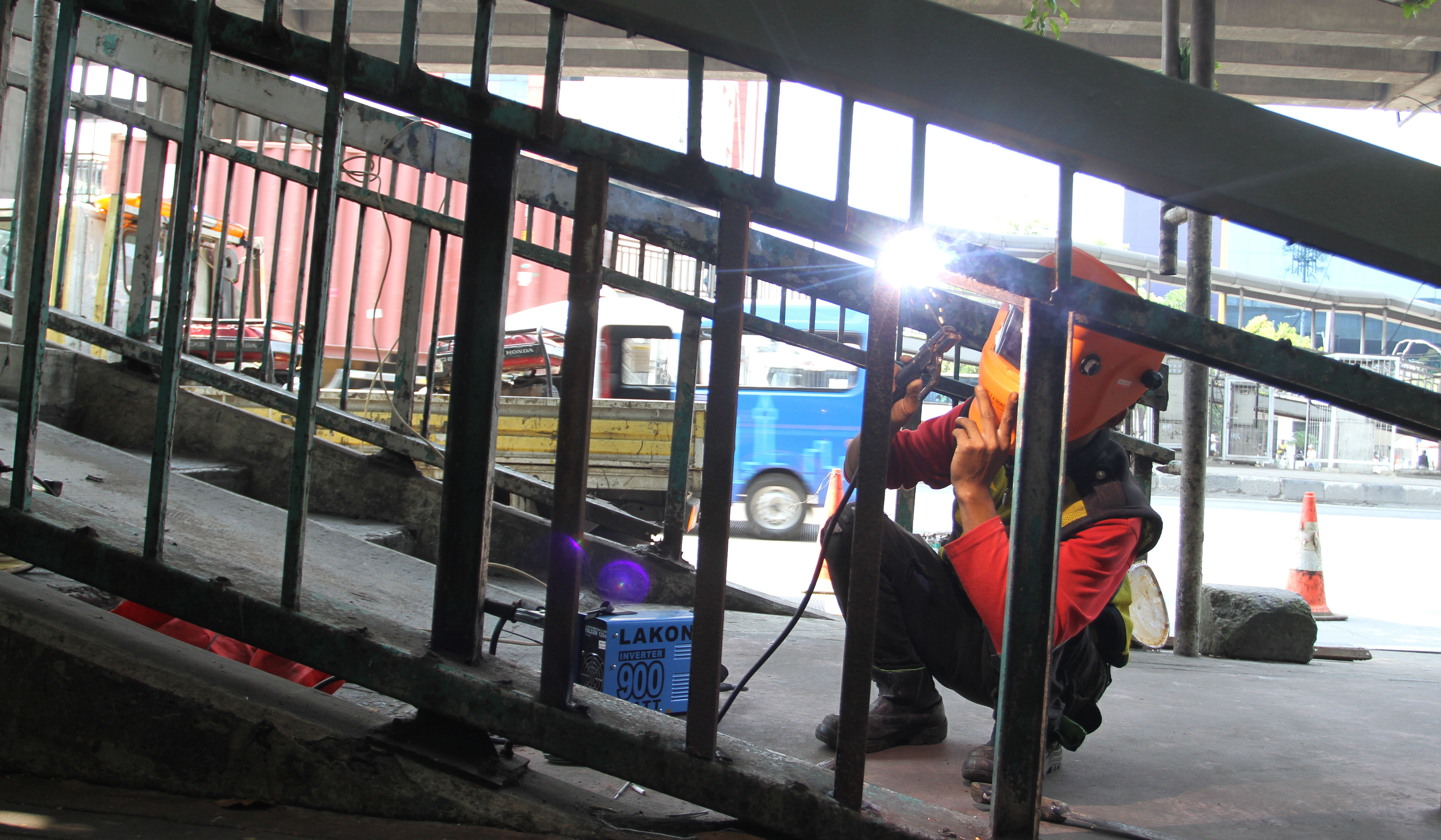 Petugas Dinas Bina Marga DKI Jakarta, memperbaiki Jembatan Penyeberangan Orang (JPO) di Jalan Yos Sudarso, Koja, Jakarta Utara. (Agus Priatna/SinPo.id)