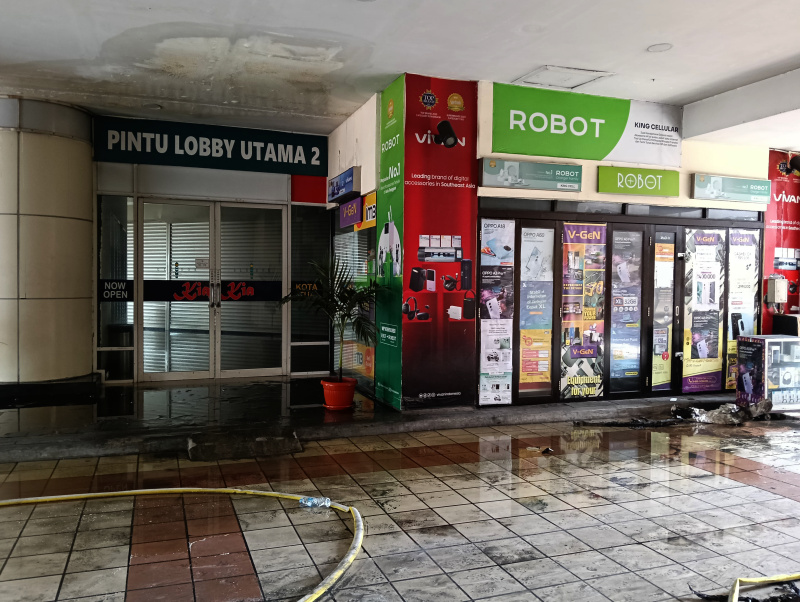 Petugas Damkar sedang melakukan penyemprotan dan pendinginan agar tidak terjadi api muncul kembali di Glodok Plaza (Ashar/SinPo.id)