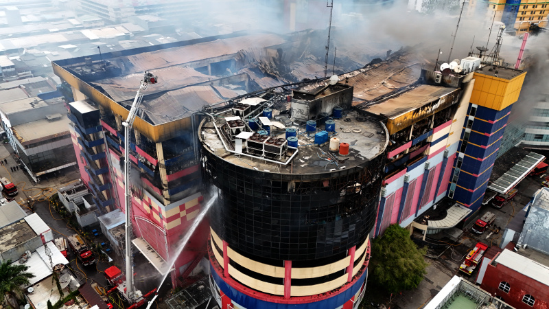 Petugas Damkar sedang melakukan penyemprotan dan pendinginan agar tidak terjadi api muncul kembali di Glodok Plaza (Ashar/SinPo.id)