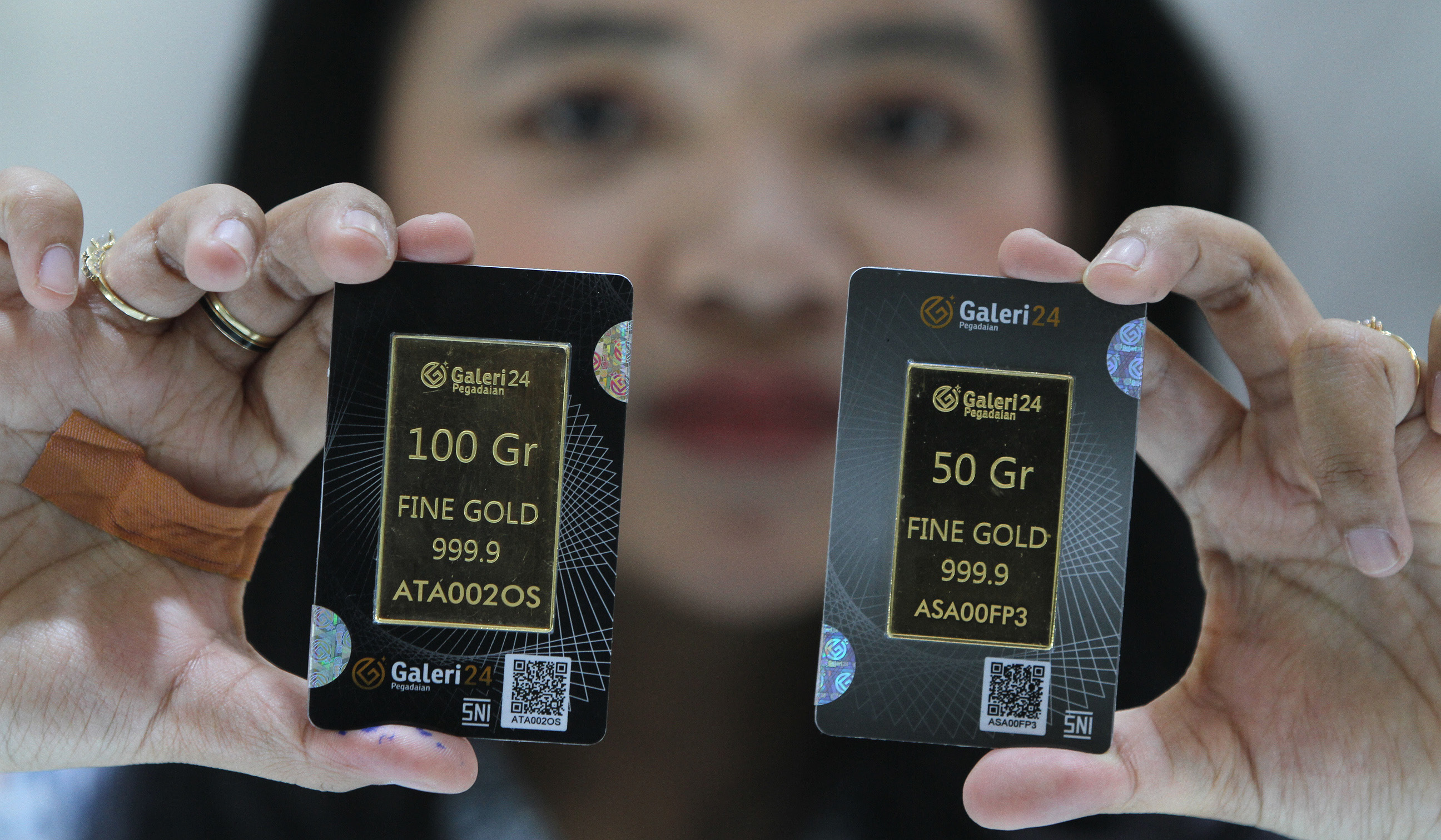 Pekerja menunjukkan emas batangan di Galeri24 Pegadaian. (Agus Priatna/SinPo.id)