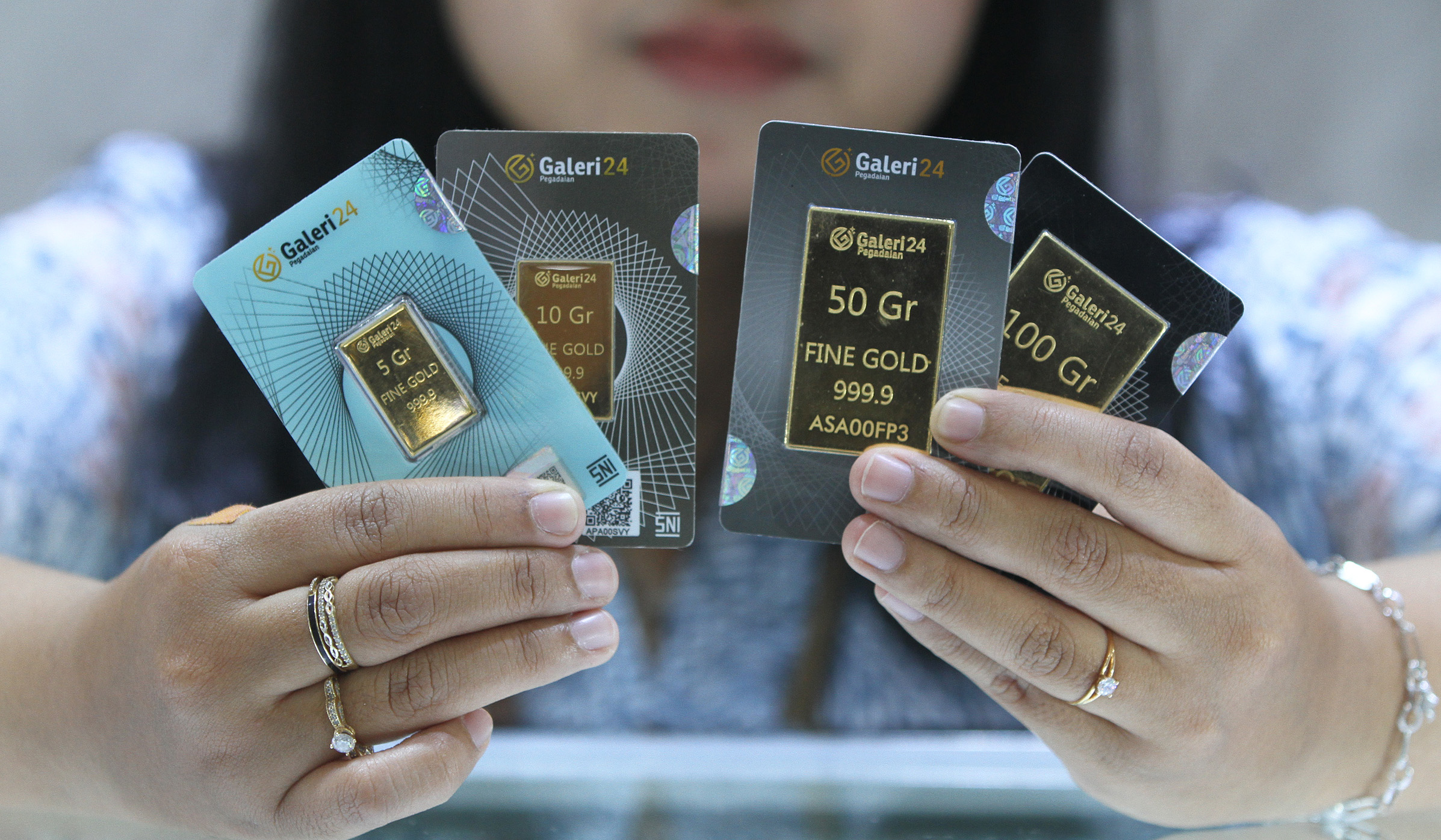 Pekerja menunjukkan emas batangan di Galeri24 Pegadaian. (Agus Priatna/SinPo.id)