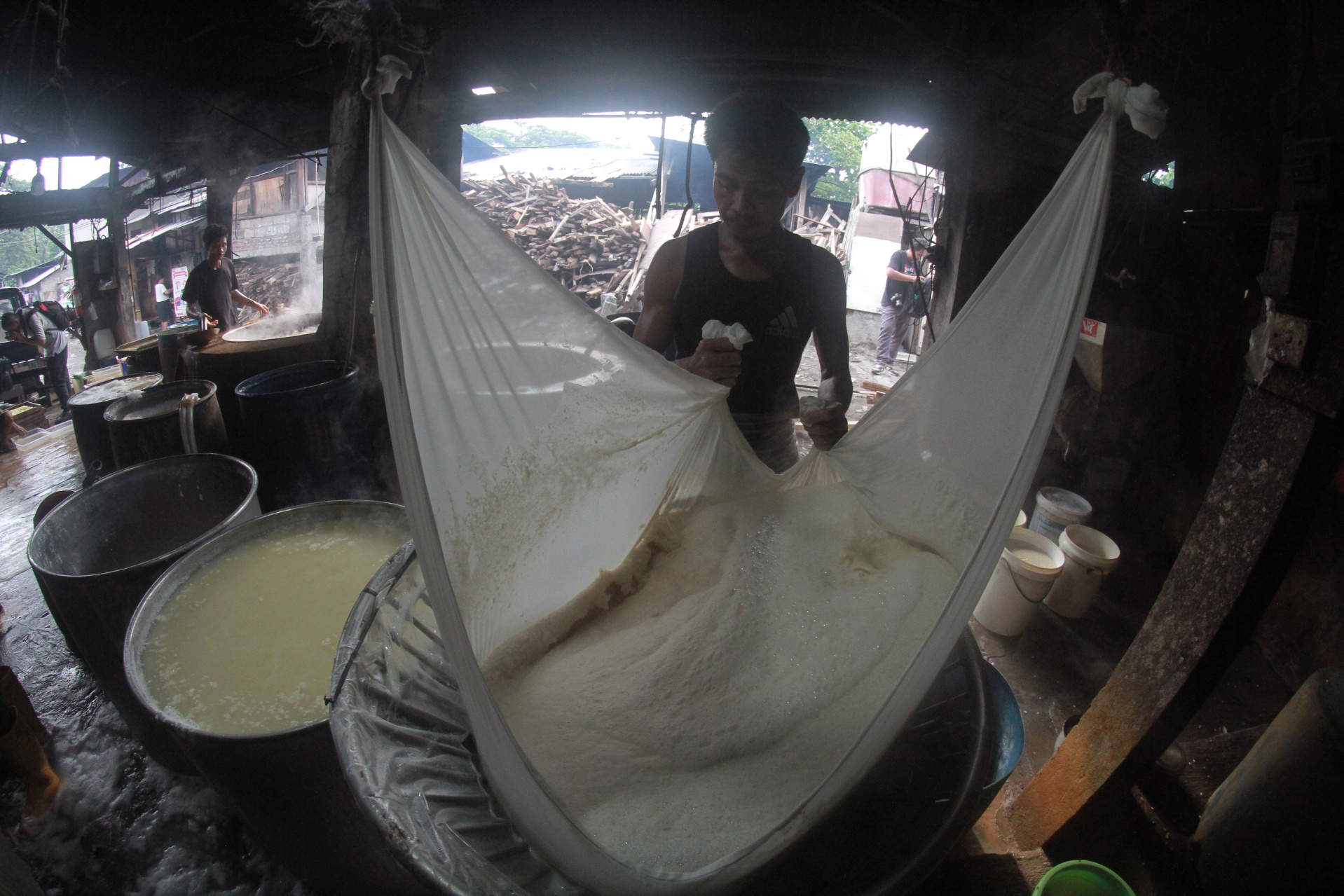 Para pekerja menyelesaikan pembuatan tahu di pabrik tahu Srengseng (Ashar/SinPo.id)