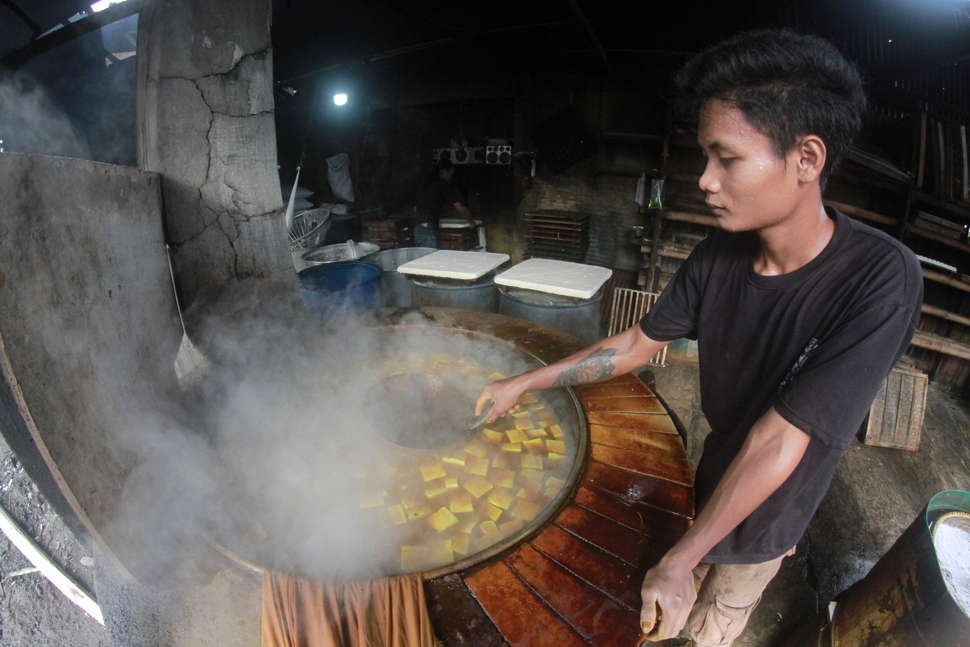 Para pekerja menyelesaikan pembuatan tahu di pabrik tahu Srengseng (Ashar/SinPo.id)