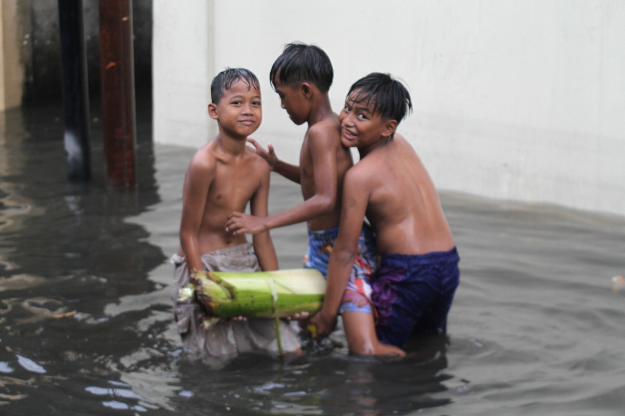 Anak-anak sedang bermain air banjir Rawa Belong (Ashar/SinPo.id)
