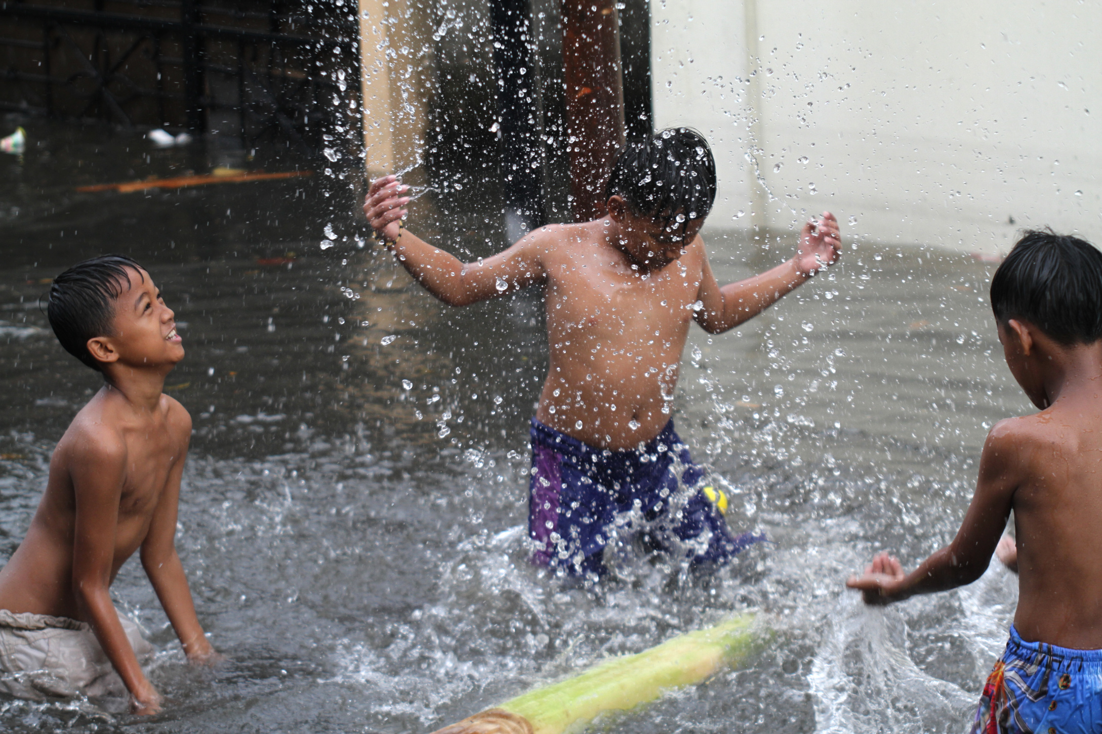 Anak-anak sedang bermain air banjir Rawa Belong (Ashar/SinPo.id)