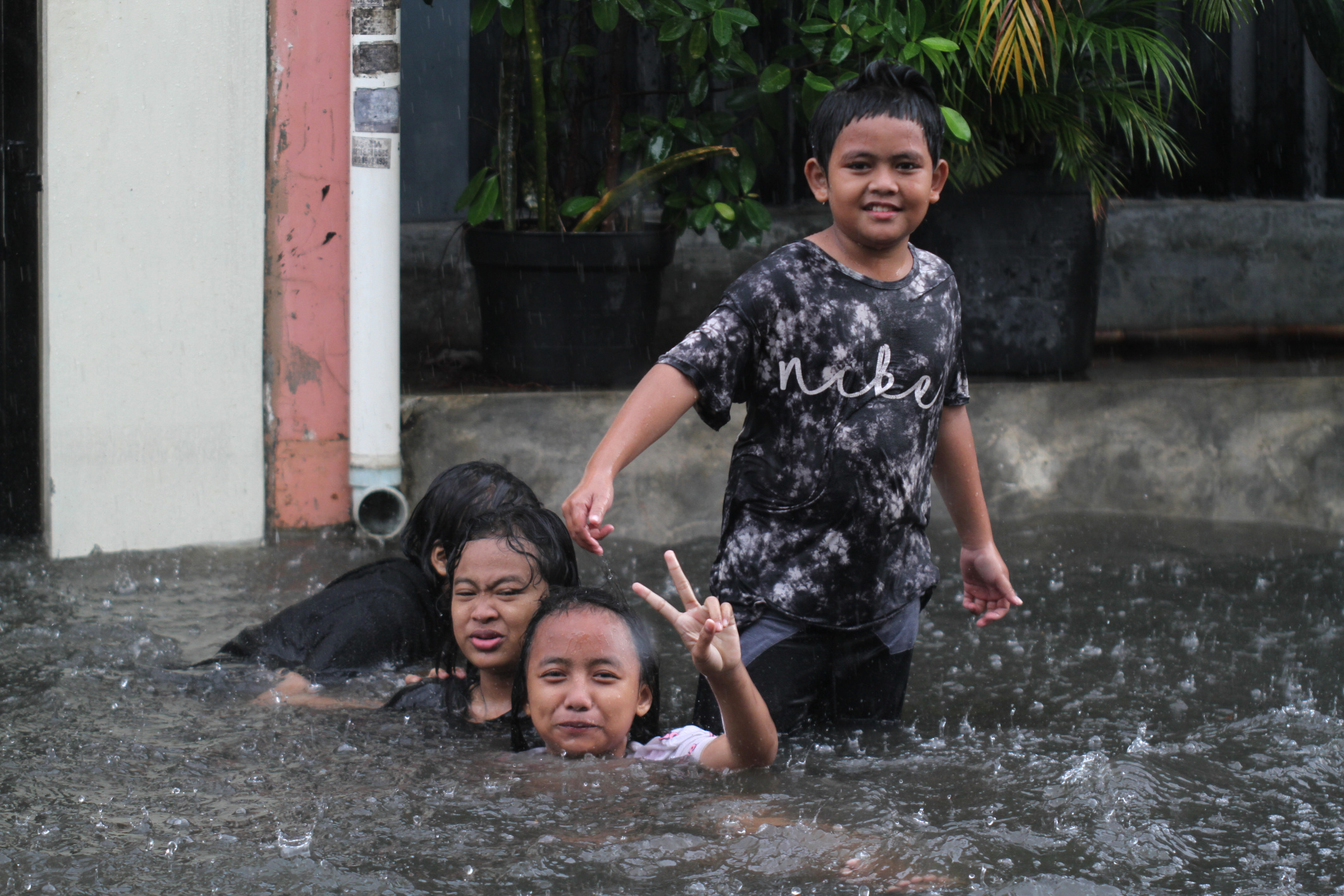 Anak-anak sedang bermain air banjir Rawa Belong (Ashar/SinPo.id)