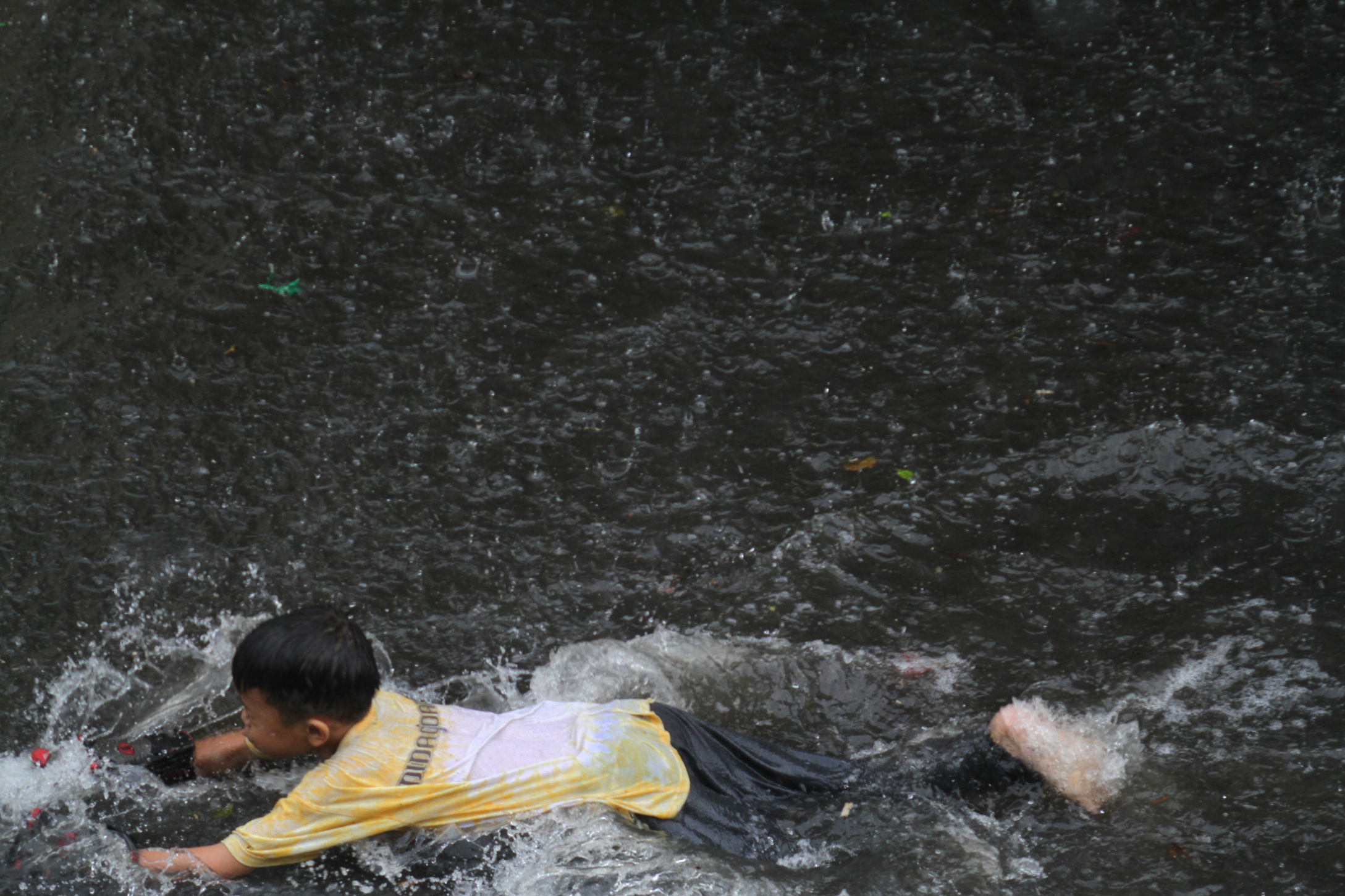 Anak-anak sedang bermain air banjir Rawa Belong (Ashar/SinPo.id)